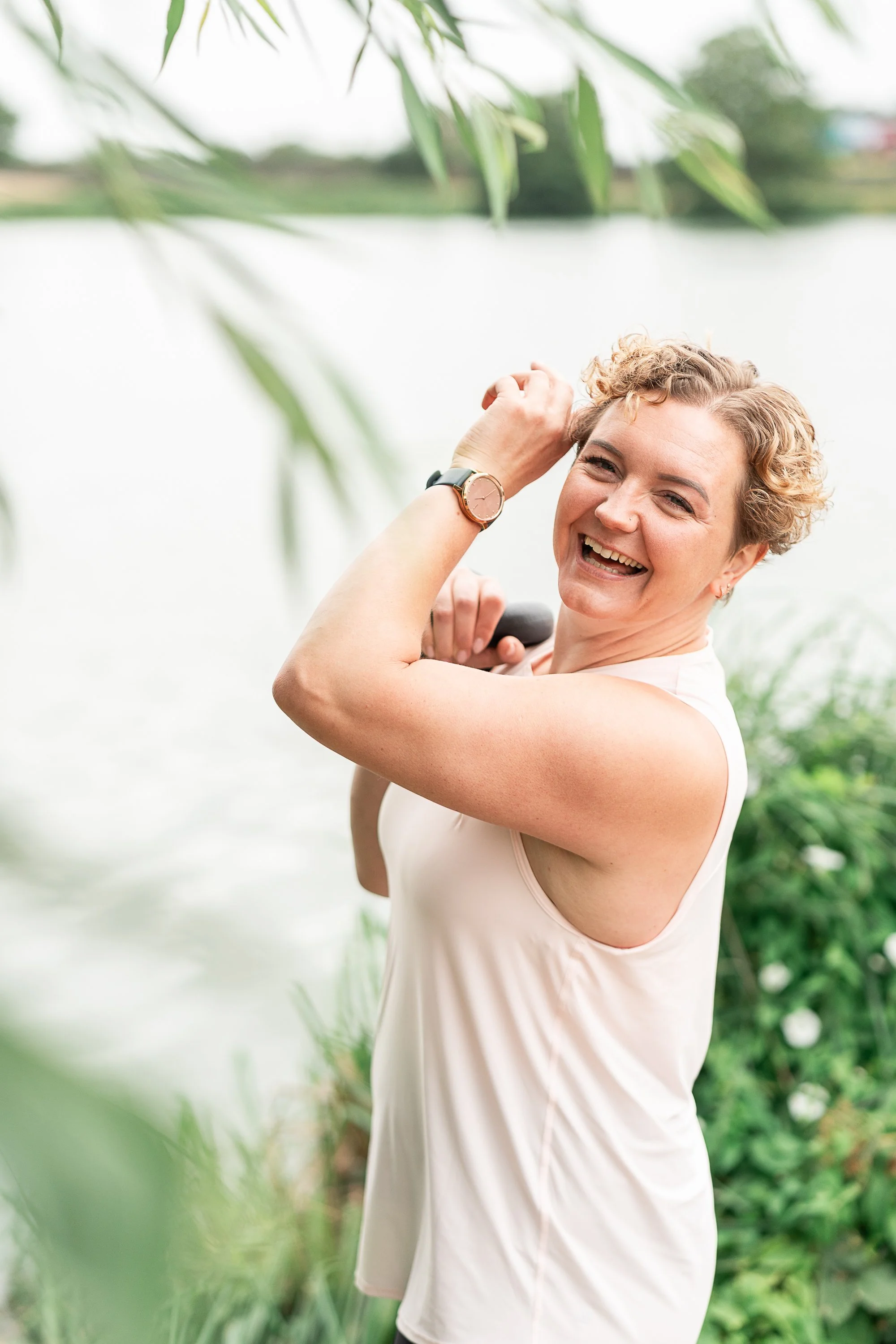 Strength and breathwork coach Rowena Ramsell laughing outdoors in Walthamstow Wetlands