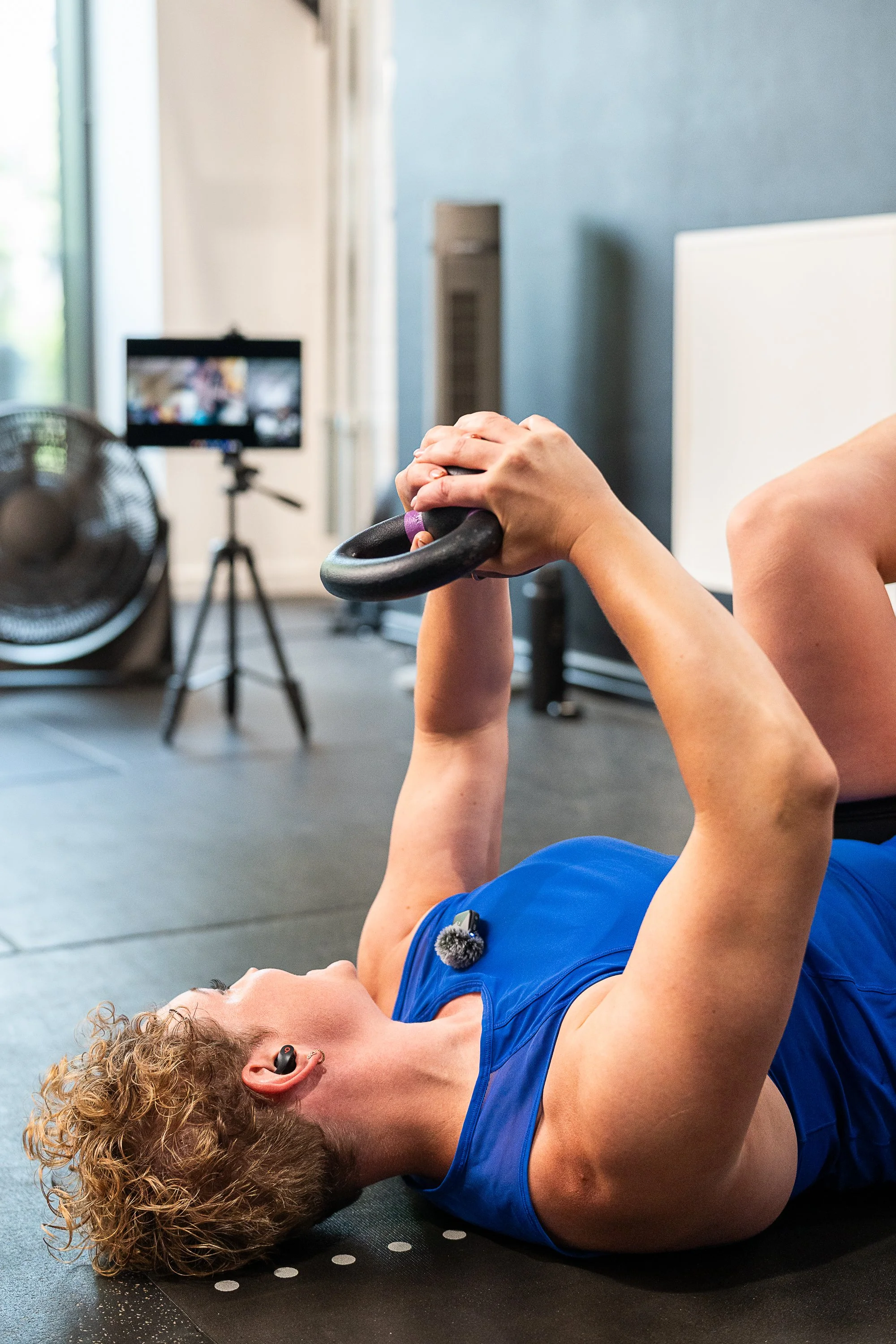 Rowena Ramsell demonstrating a floor-based kettlebell exercise in her strength training studio Move Strong