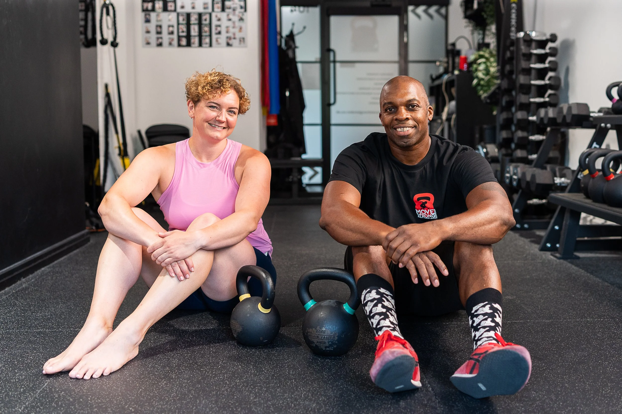 Rowena Ramsell sitting with a fellow fitness trainer and kettlebells in Move Strong London