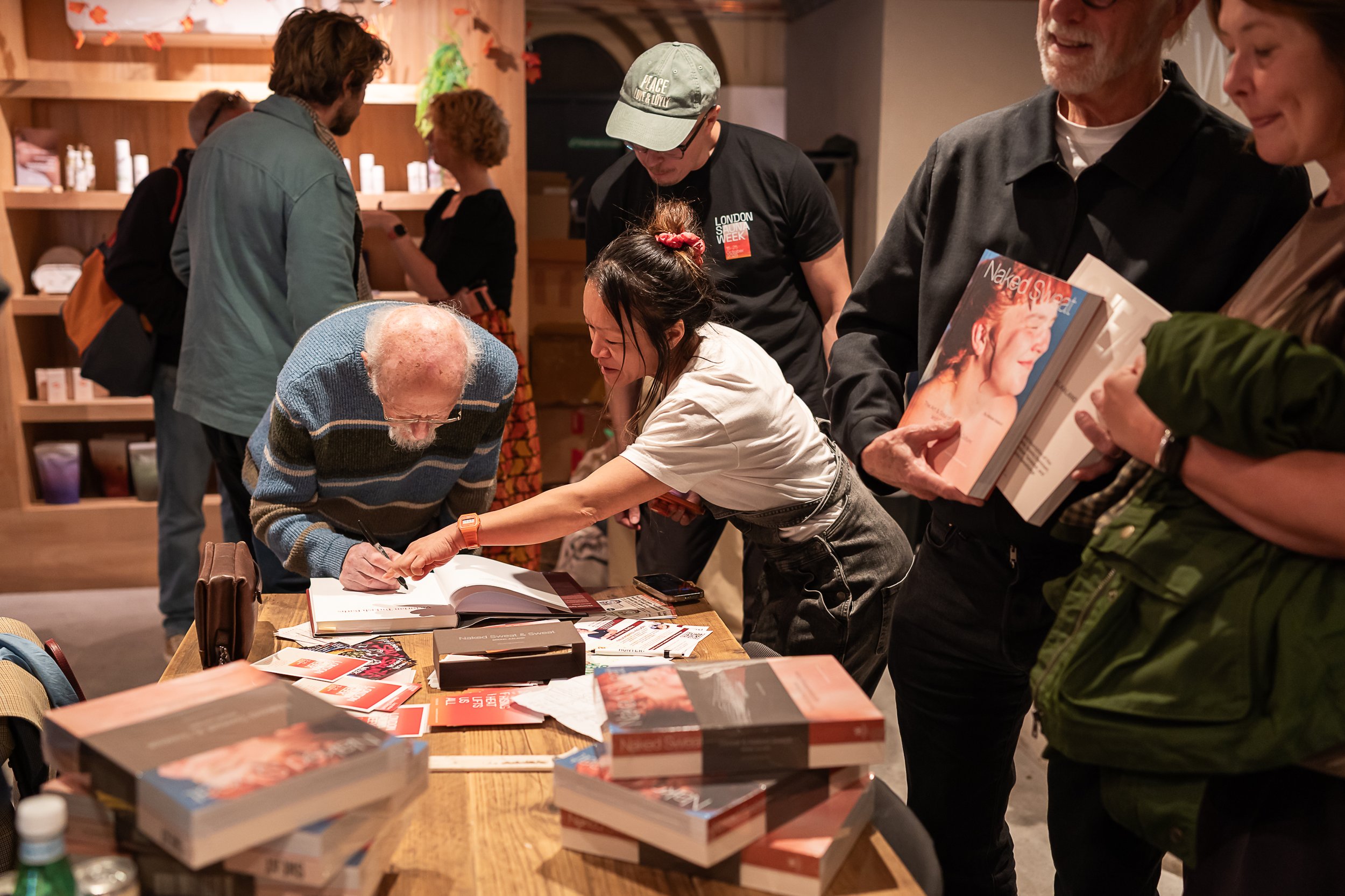 Malcolm Shifrin signing a book during the London Sauna Week event