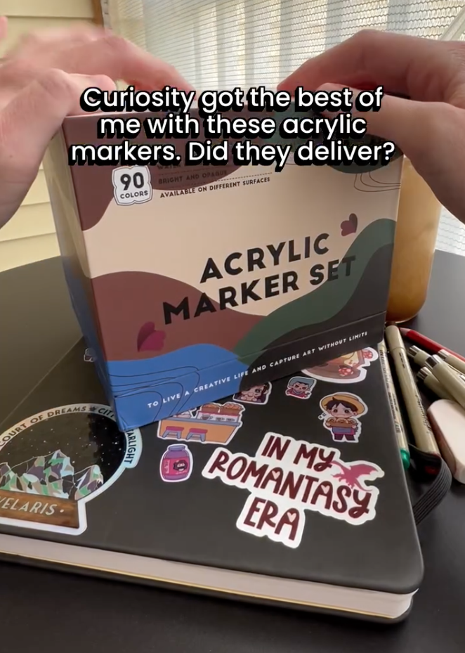 Showing an acrylic marker set on top of a nova covered in cute Gibley style stickers that says in Meijer, romantic Ciara