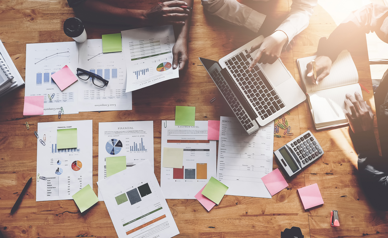 Business-People-Meeting-using-laptop-computer,-calculator,-notebook,-stock-market-chart-paper-for-analysis-Plans-to-improve-quality-next-month.-Conference-Discussion-Corporate-Concept-905819004_1310x805.jpeg