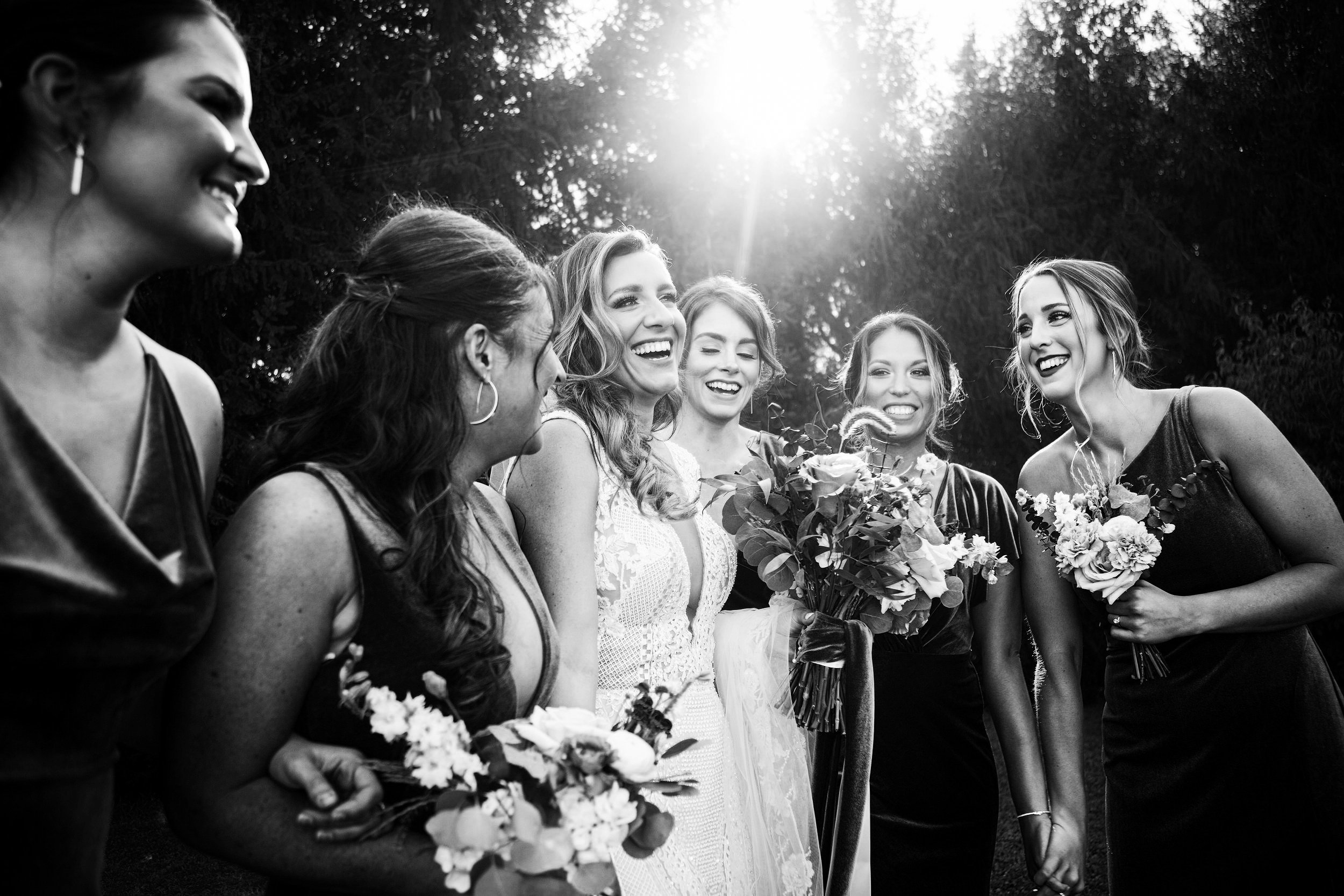 bride and bridemaids laugh black and white