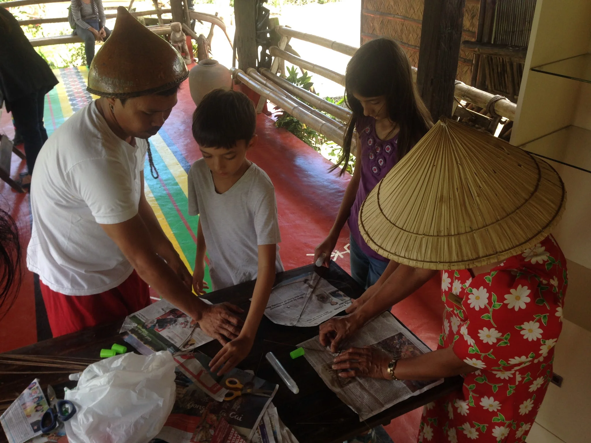 Making kites from newspaper, long twigs, glue and thread