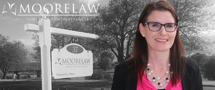 Photo of Helen Hale with the Moore Law sign in the background.