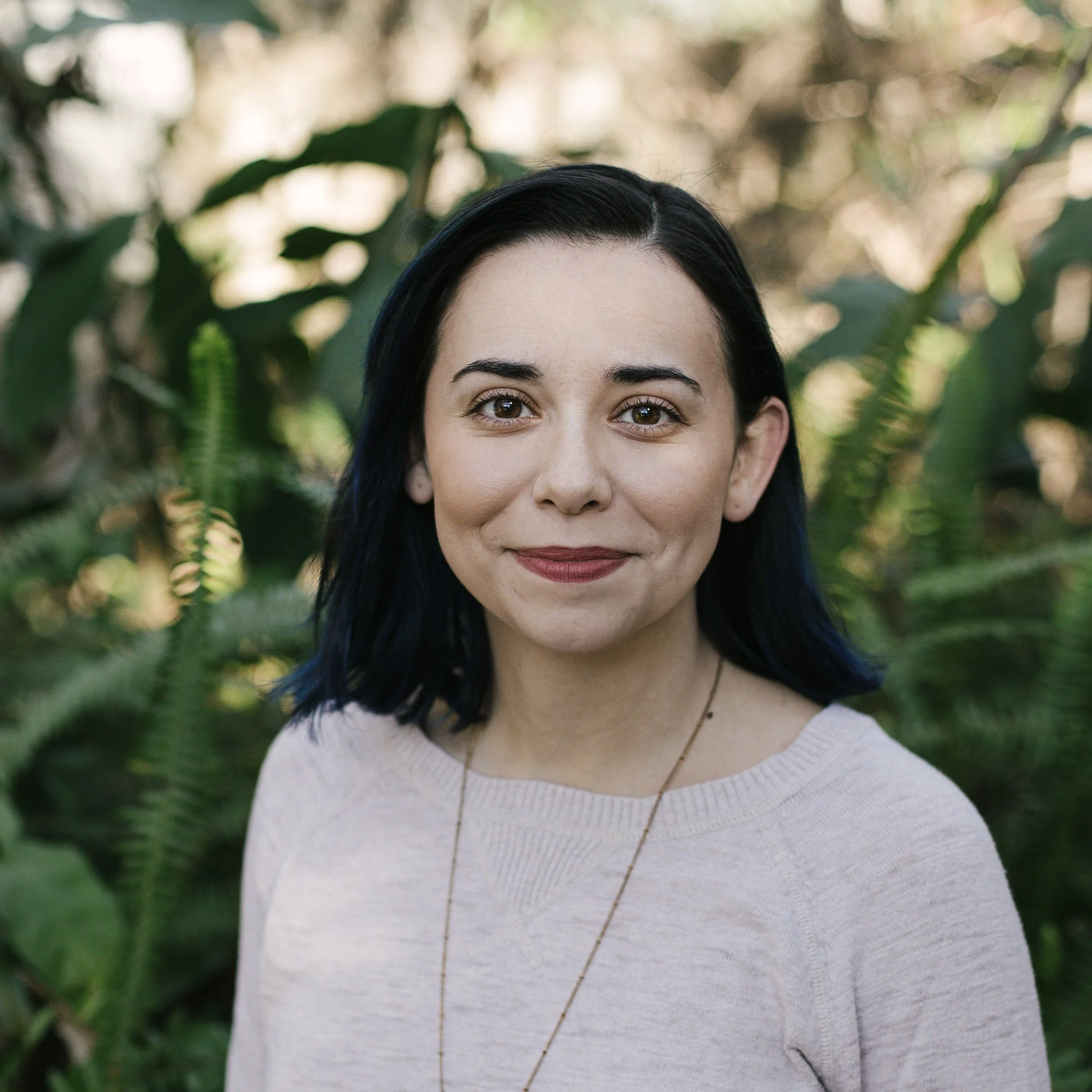 Brunette woman with greenery behind