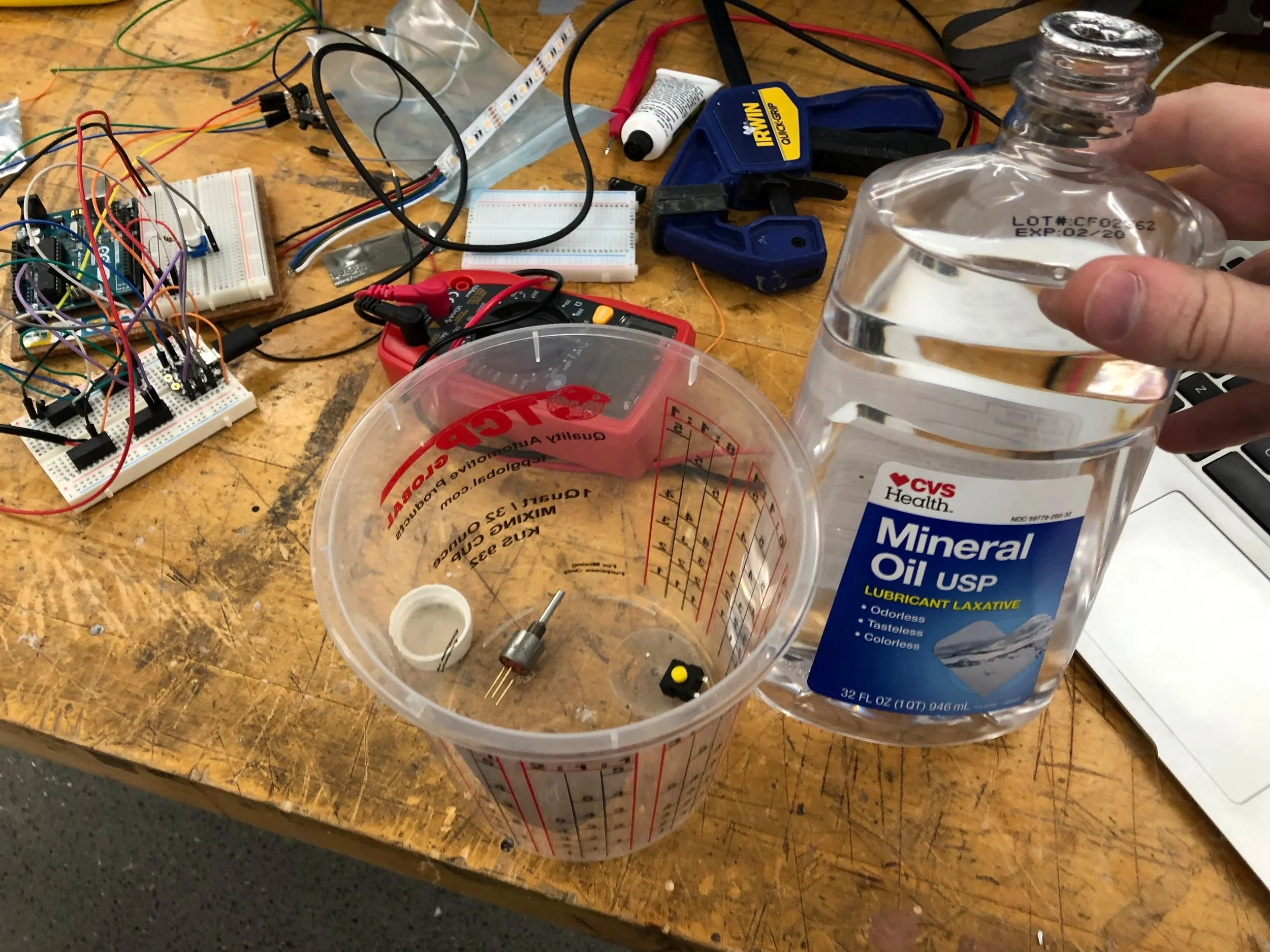 Using mineral oil (non-conductive, non-corrosive, and effectively incompressible) to replace the air inside of the potentiometer and toggle button