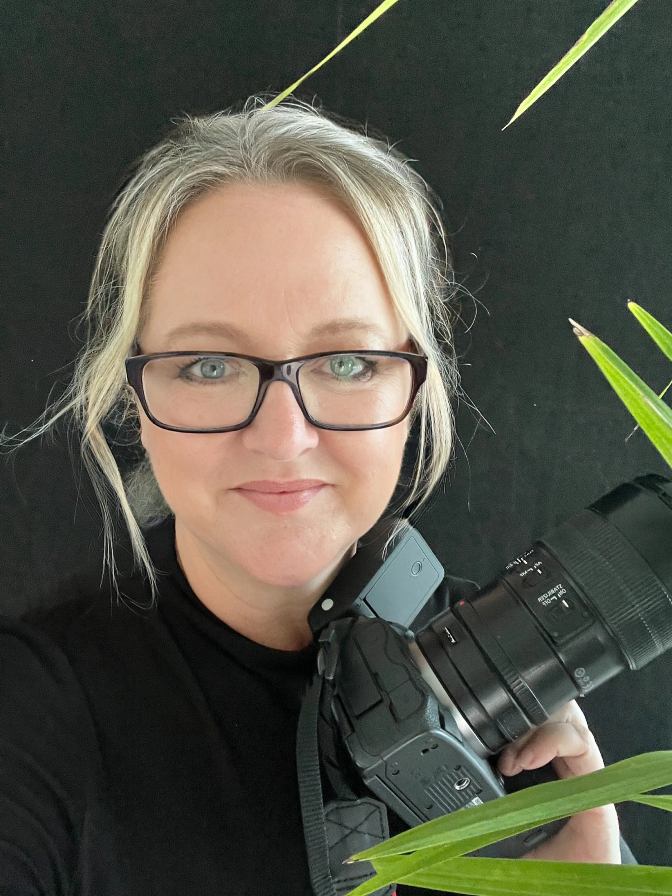 Keri Little, executive and corporate portrait photographer, holding her camera
