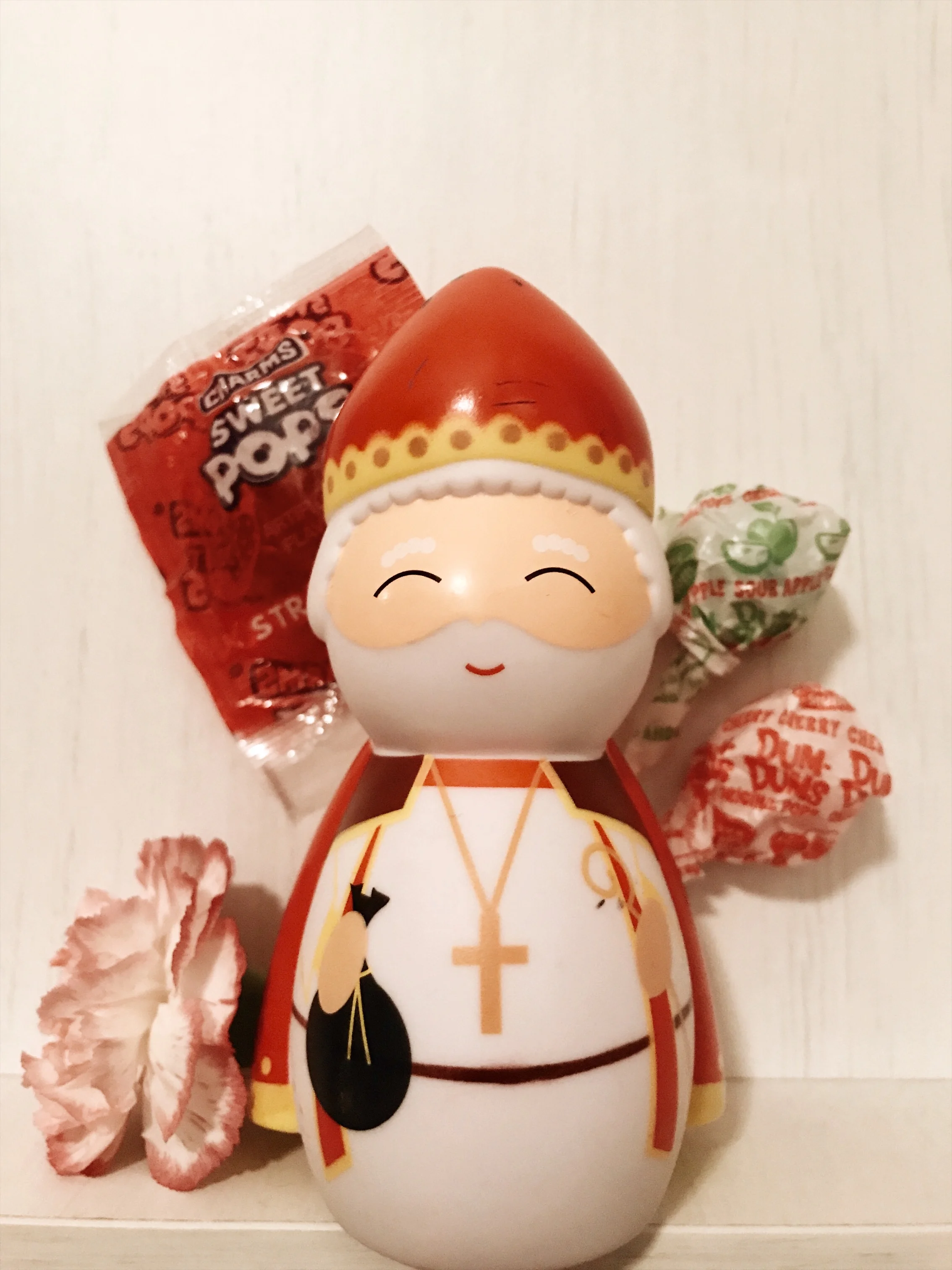 Saint Nicholas Shining Light doll's about to be dropped into a cute little toddler shoe with some lollipops.