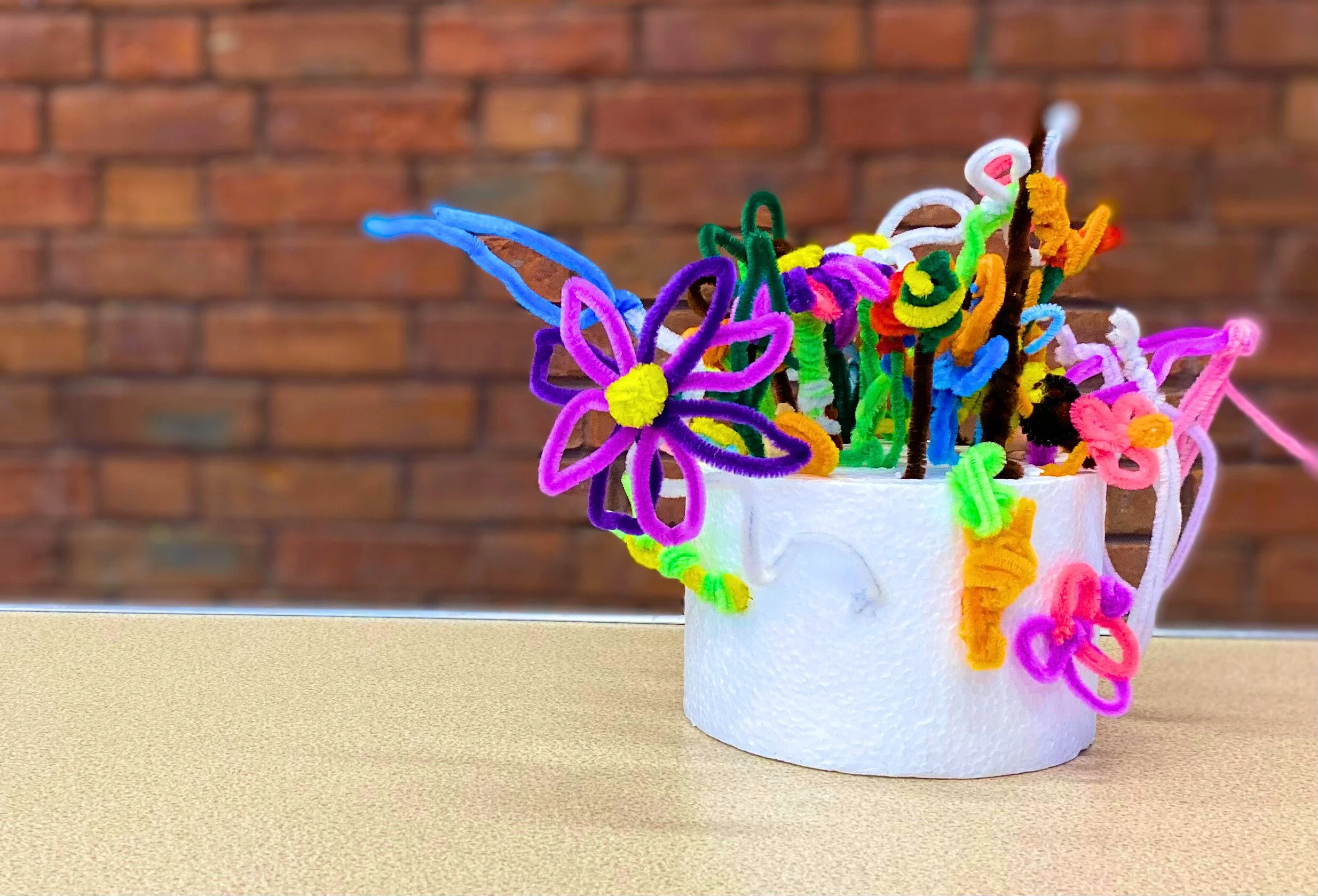 A flower garden made of pipe cleaners in a bed of styrofoam