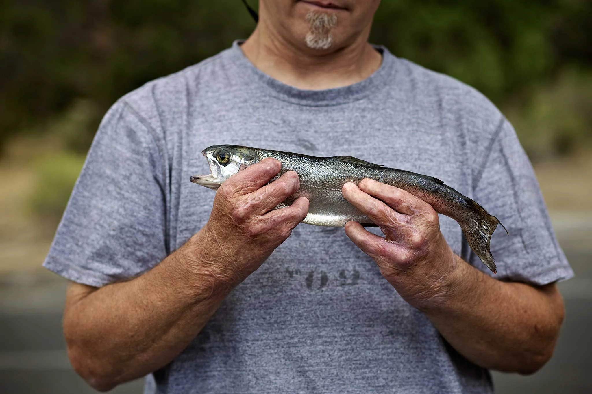 larry davis, injured firefighter, showing off the trout he caught on a fishing trip