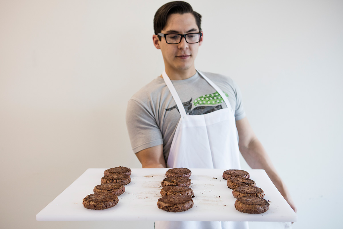 beyond meat research associate john berriman displays patties cooked for sensory testing.
