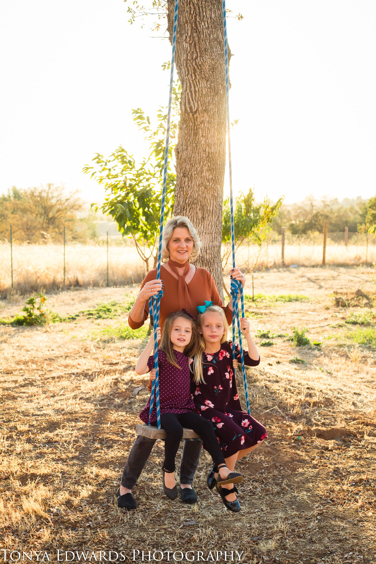 Tonya Edwards | Oroville Photographer | grandmother pushing granddaughters on swing golden hour