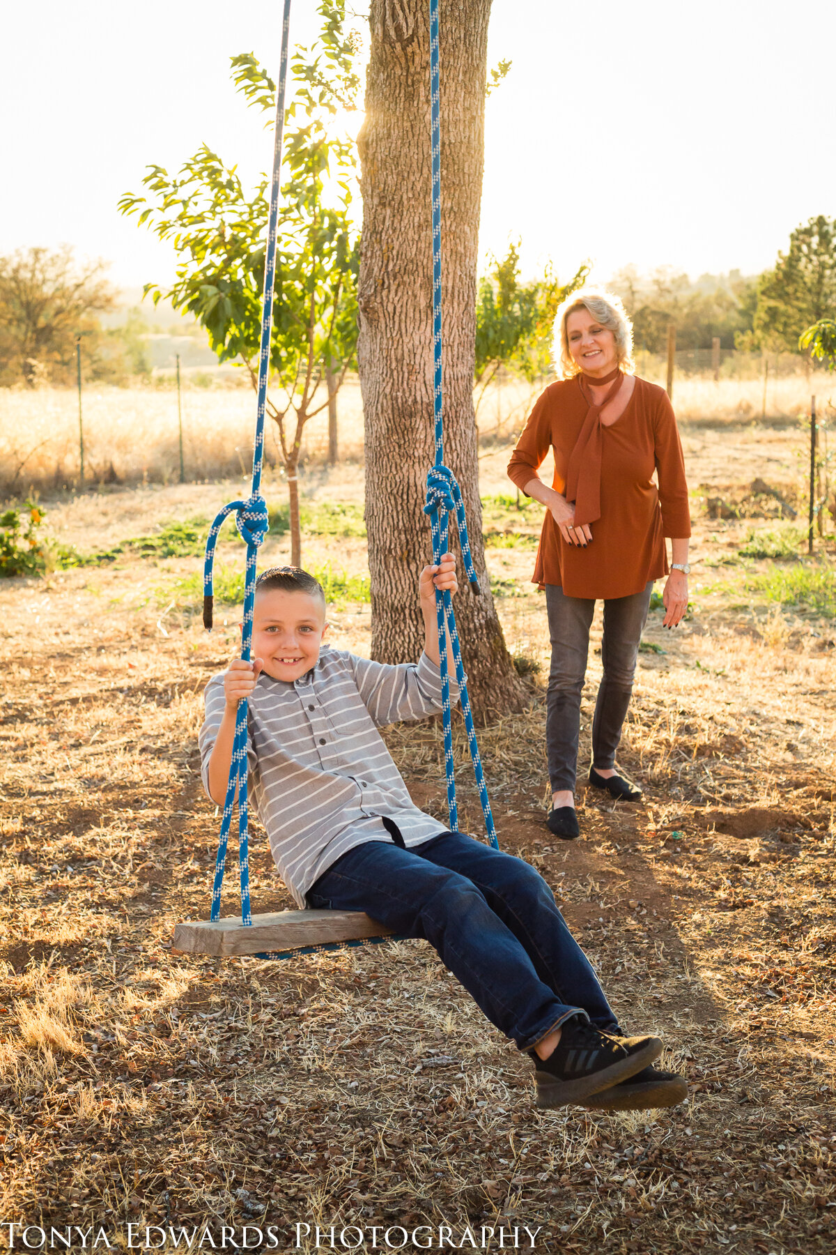 Tonya Edwards | Oroville Family Photographer | grandmother pushing grandson on tree swing during golden hour