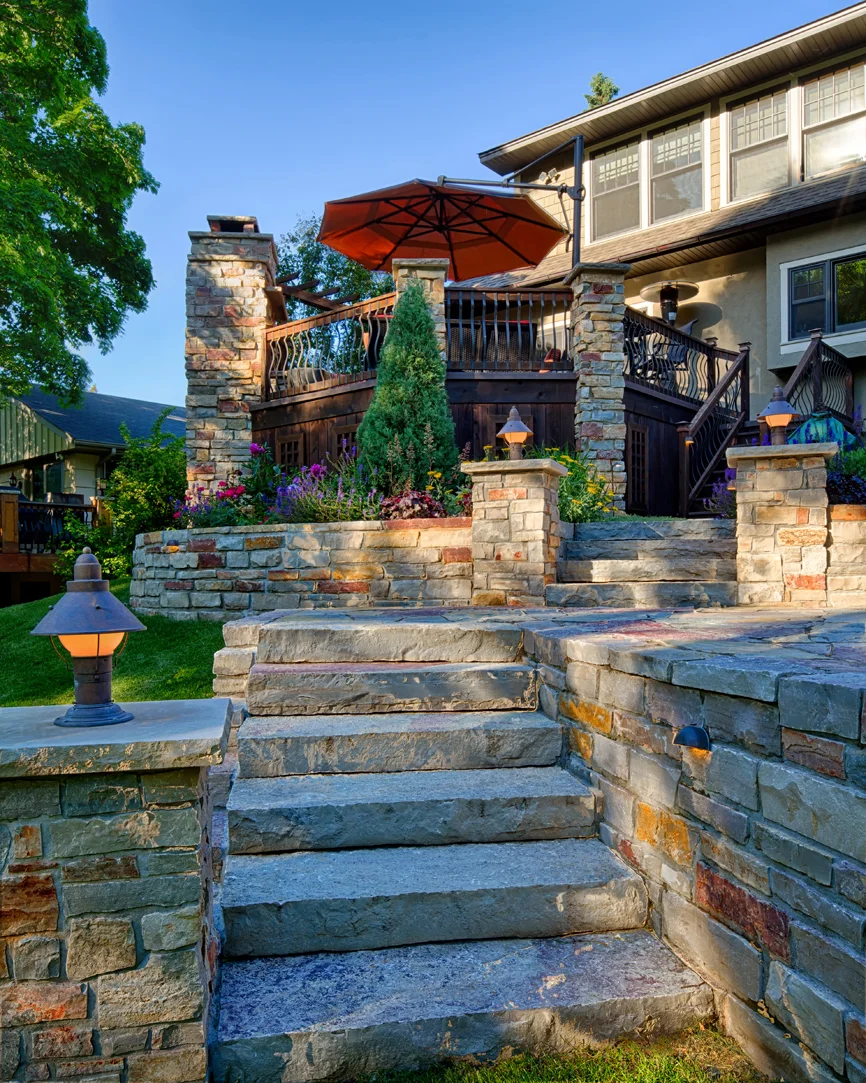 Edina homeowners love being outdoors, both with family and friends. Expanding their entertaining space to the deck and levels below include the patio, hot tub outdoor kitchen, fire pit and steps leading into the yard. 