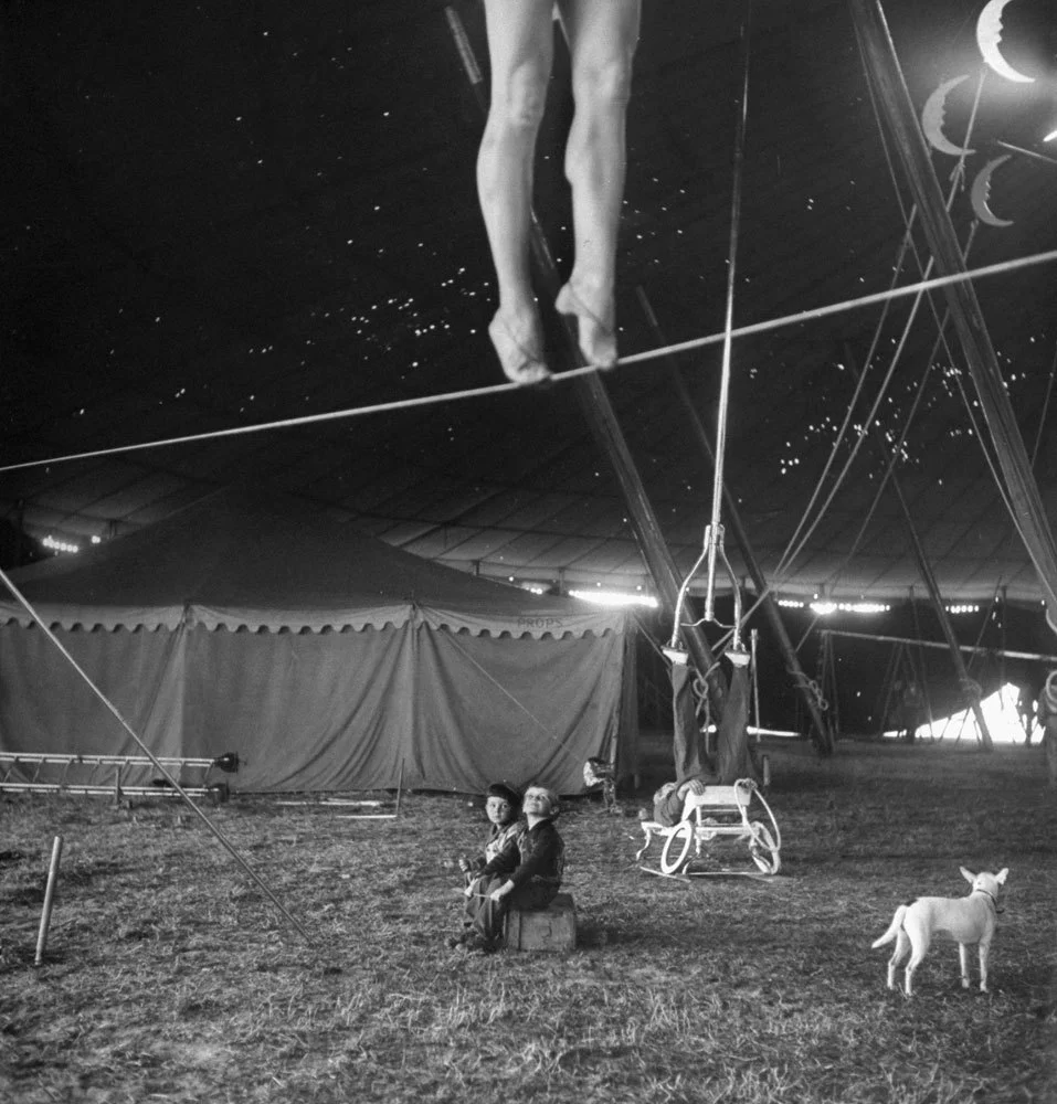 life :
From a story on the Ringling Bros. Circus in the April 4, 1949, issue of LIFE. The caption for this picture: “Nothing but circus all day every day is the happy fate of these two performers’ tots, who sit around the big tent watching as the pretty Miss Lola practices on a tightwire and an acrobat balances an odd contraption on his feet.” See more photos by Nina Leen here. (Nina Leen—Time & Life Pictures/Getty Images)