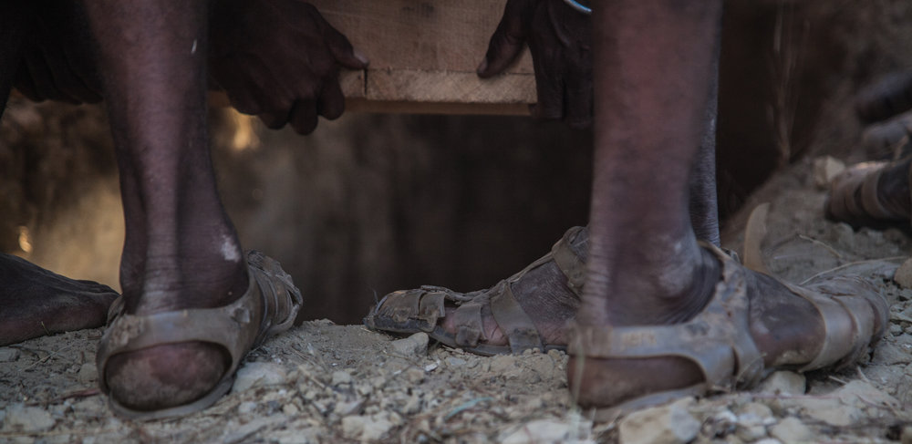  The coffin is lowered into the ground where his mother adorns it with the items he will need in the afterlife 