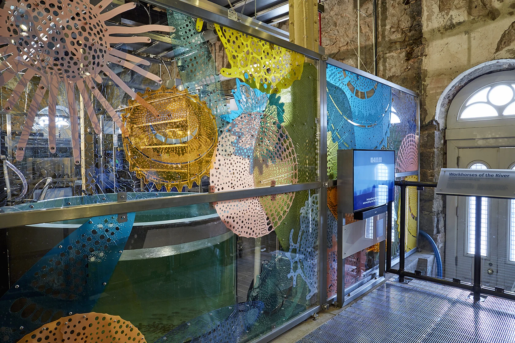 Diatom Lace, a transparent mural by Stacy Levy, uses colorful enlargements of microscopic diatoms to enclose the Living Laboratory at the Mussel Hatchery.