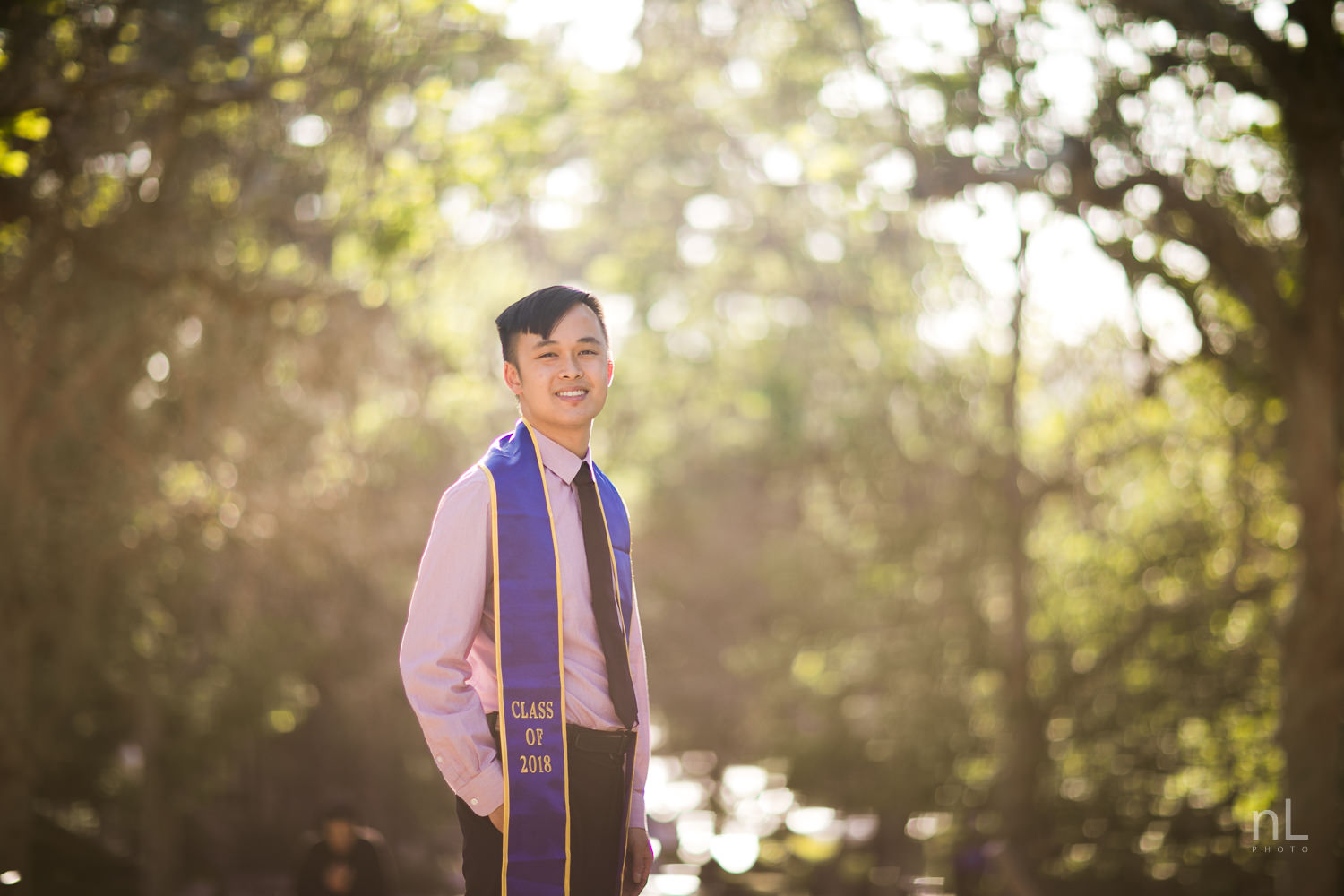 los-angeles-ucla-senior-graduation-portraits-bruinwalk-bokeh-guy-sash-smiling-at-sunset