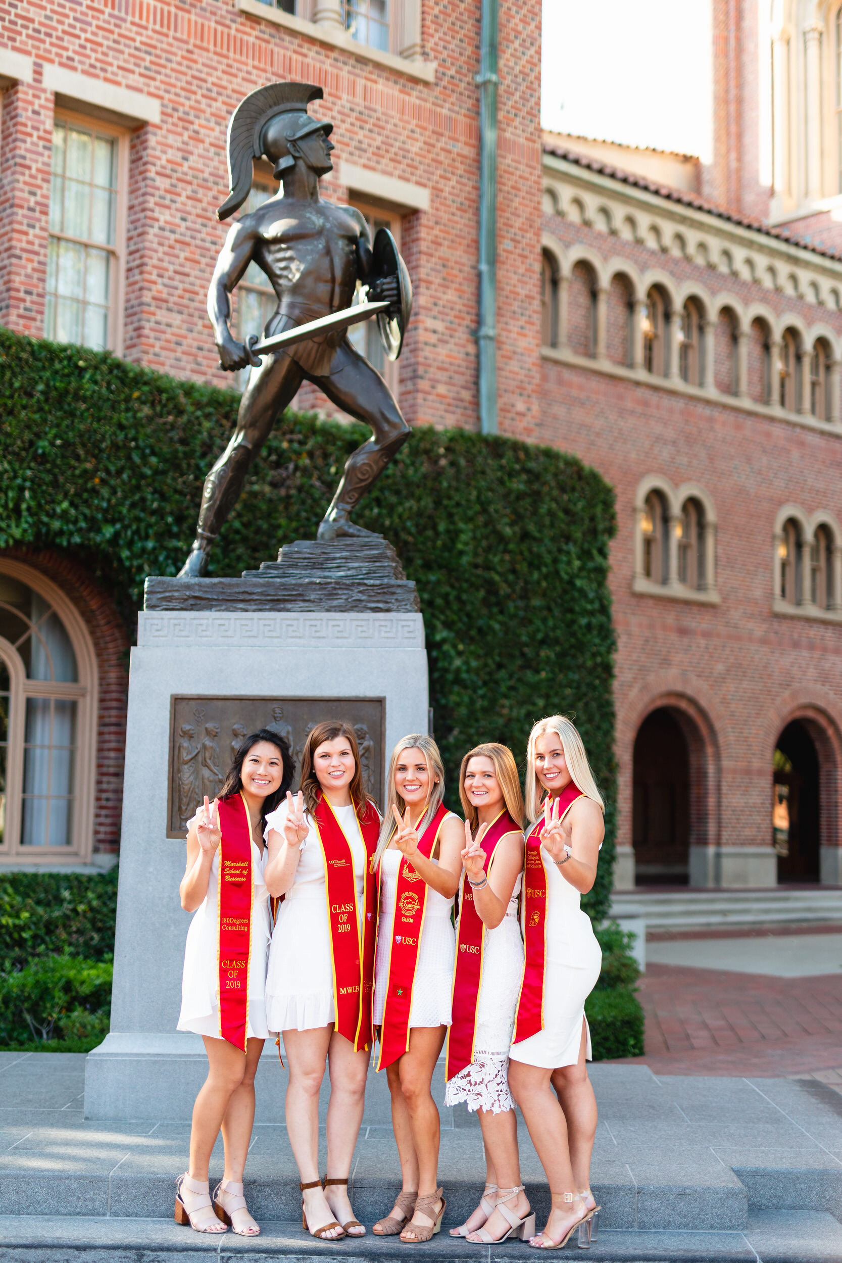 USC graduation portrait of best friends at Tommy Trojan with Victory sign