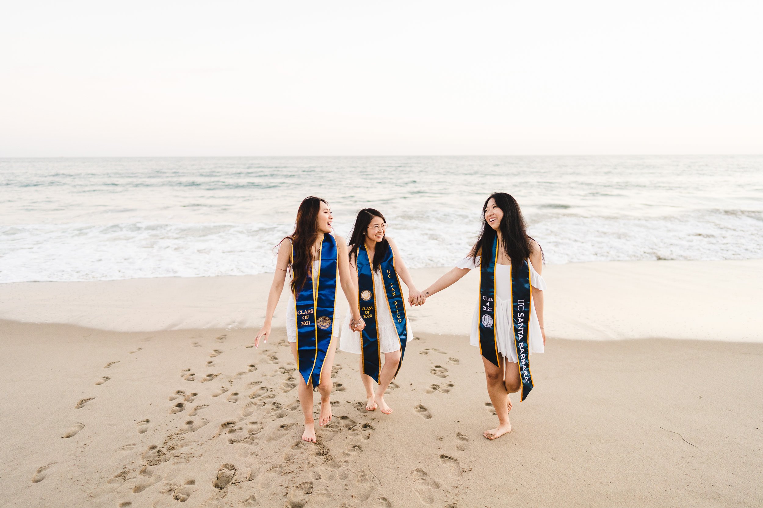 graduation portraits for best friends at the beach, action shot walking at sunset, UCLA UCB UCSD UCSB 