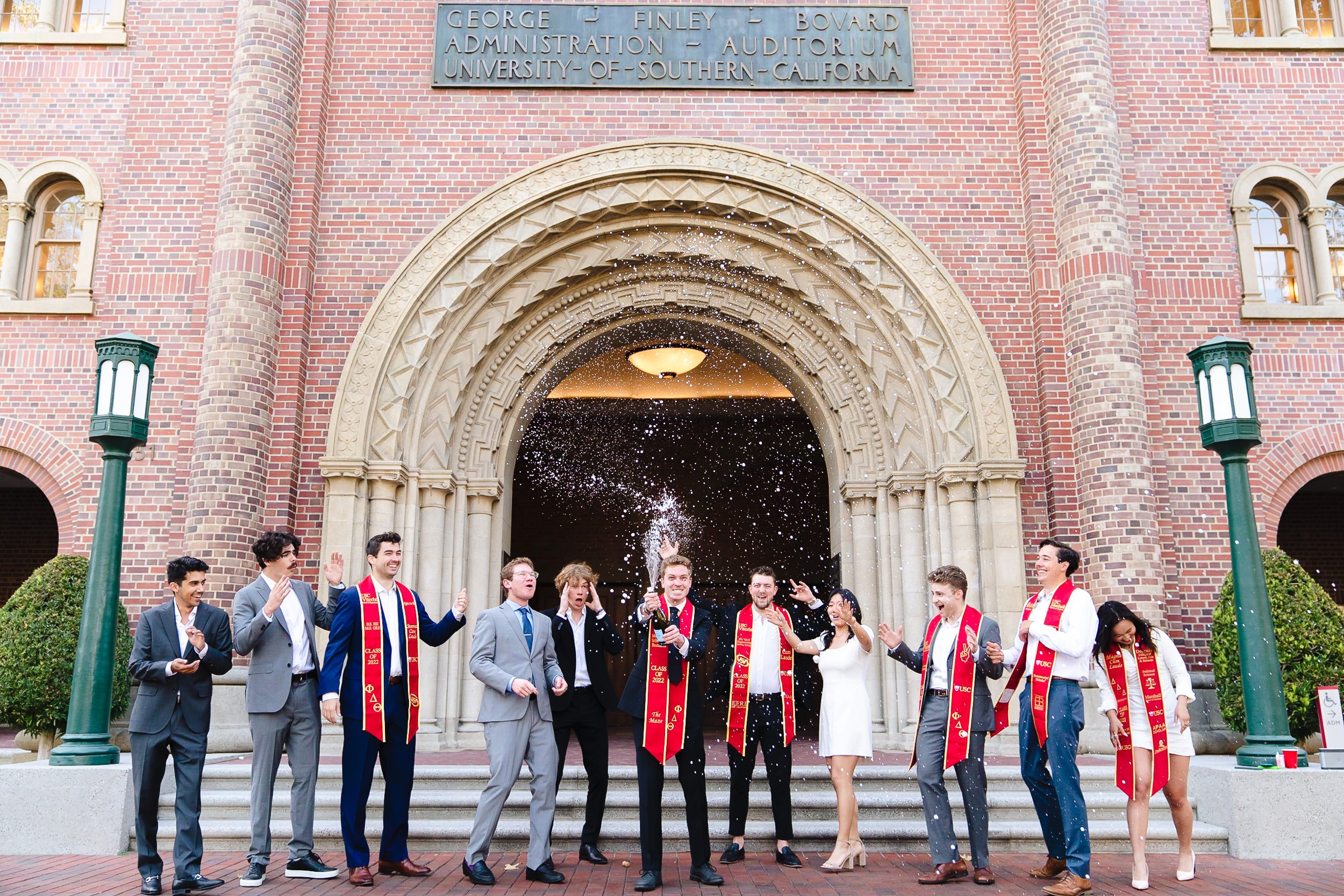 USC graduates celebrating with champagne at Bovard 