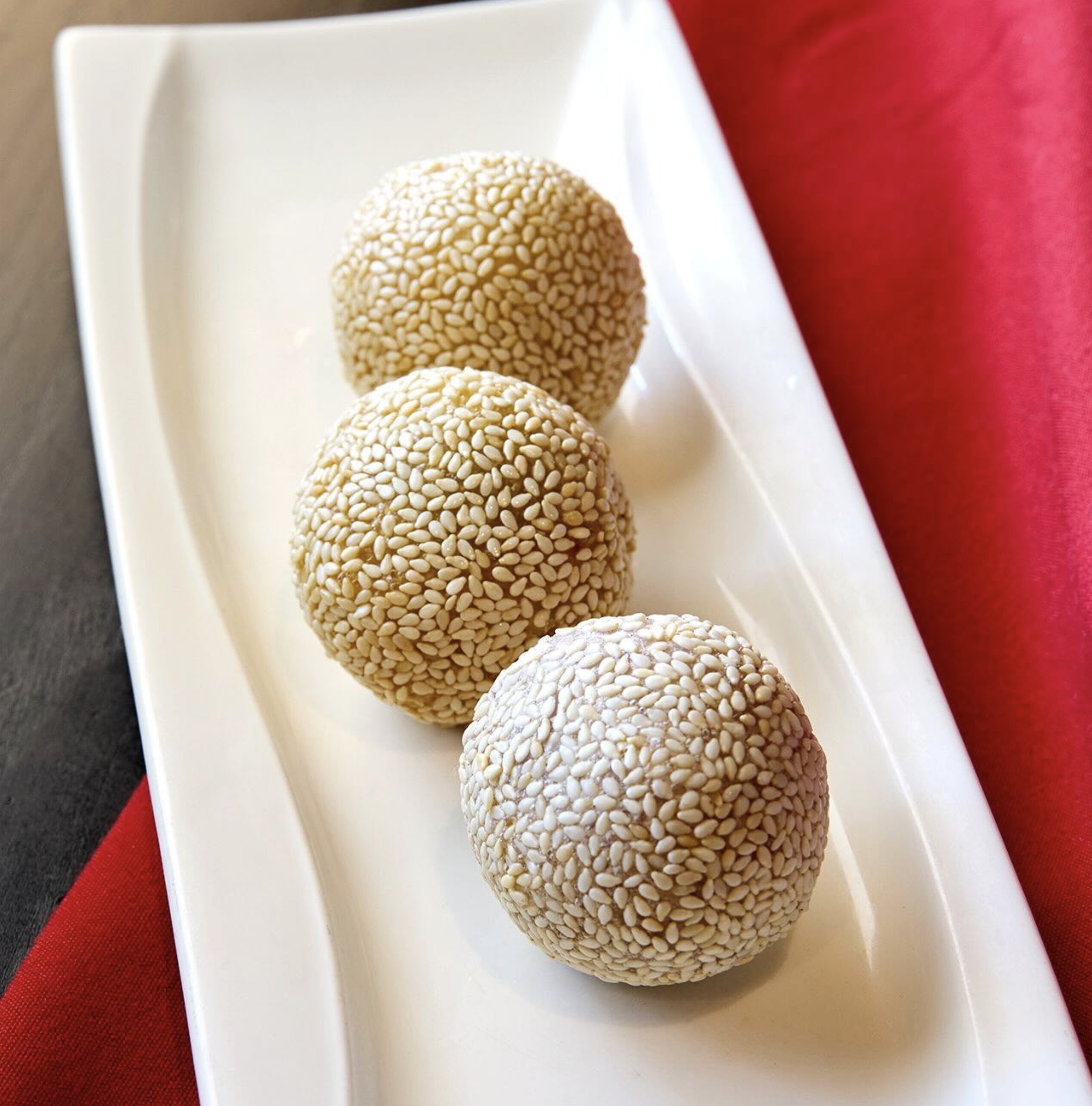 The Sesame Balls, fried mochi coated in sesame seeds filled with Chocolate, sweet red bean, and taro root, served at Royal China