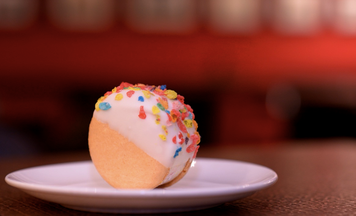 The Cereal Milk Ice Cream Macaron, giant Macarons sandwich a slab of ice cream, partially coated in a white chocolate glaze and sprinkled with fruity cereal pieces, served at Royal China
