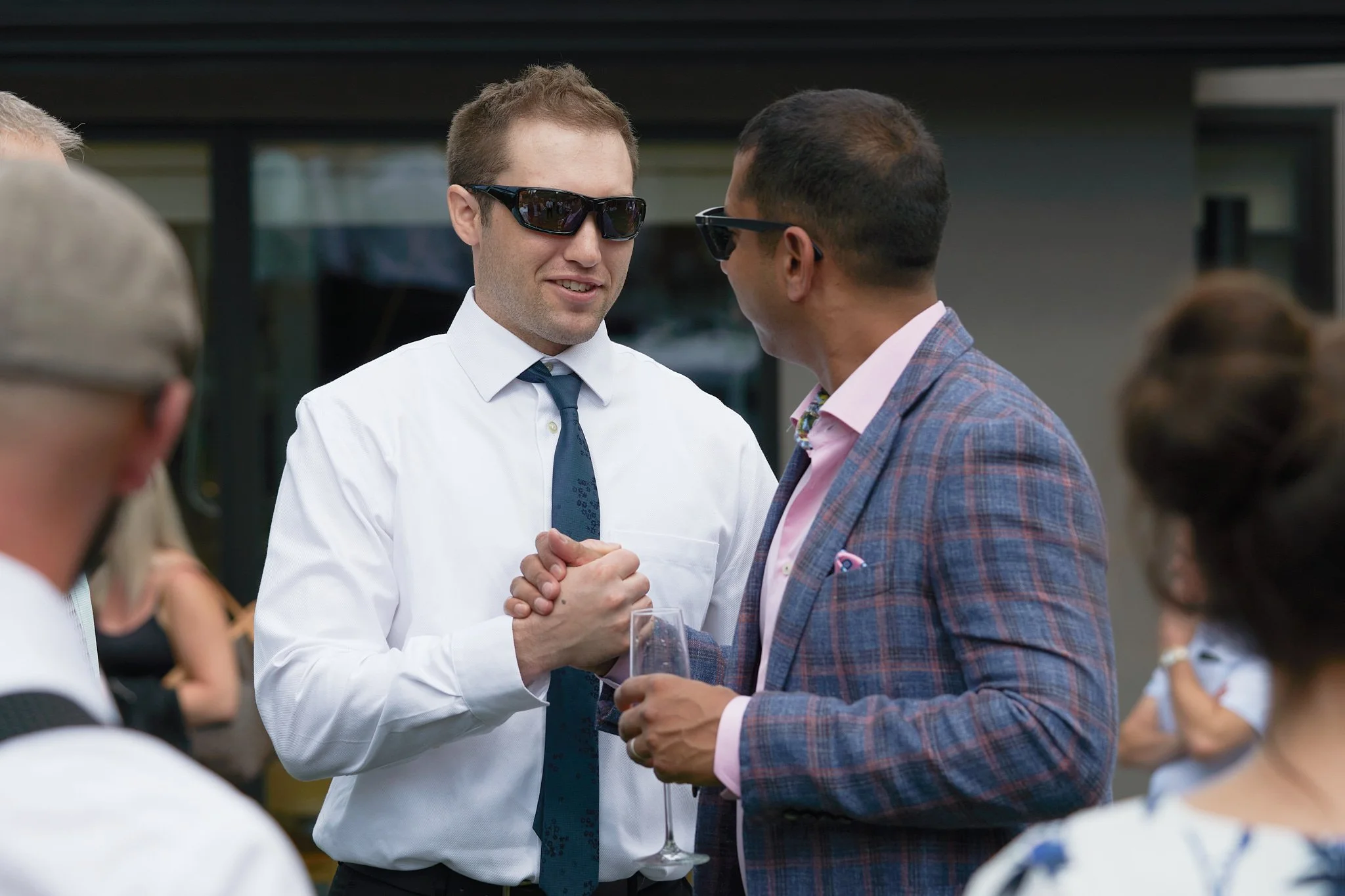 Sunglasses and brothers-in-law at a backyard wedding reception in Calgary. Connection captured by Stance Creative event photography.
