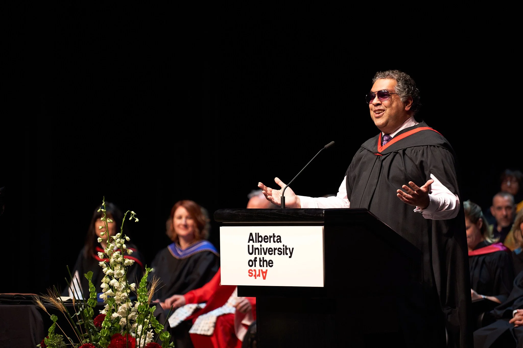 Mayor Naheed Nenshi delivering an inspiring address at Alberta University of the Arts (AUArts) graduation in Calgary. Dynamic stage moment captured by Stance Creative, professional event photographer.