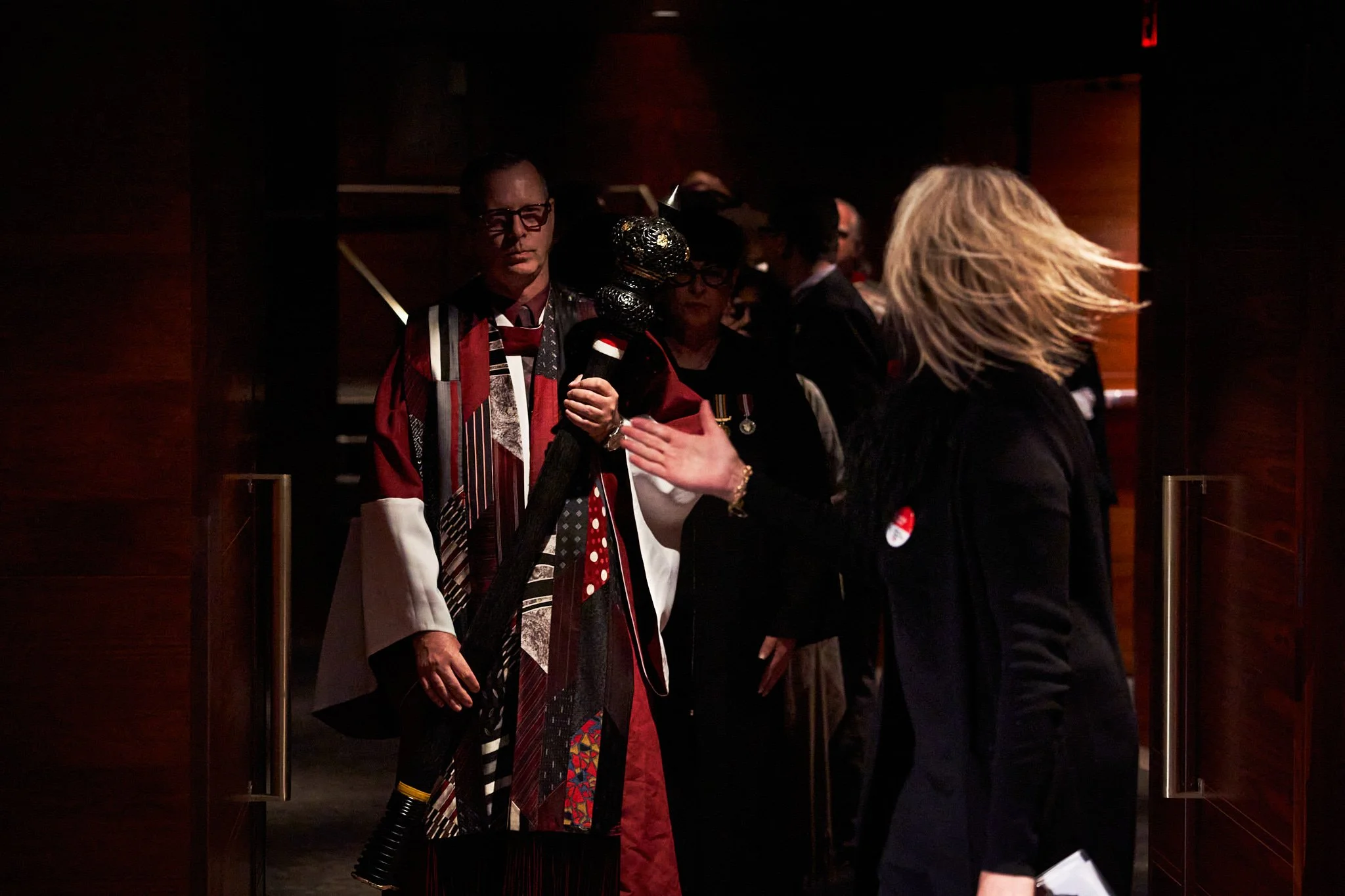 Academic procession for the AU Arts Convocation Ceremony with mace bearer in ornate multicolored robe. Rich cultural and ceremonial atmosphere. Image by Stance Creative event photography.