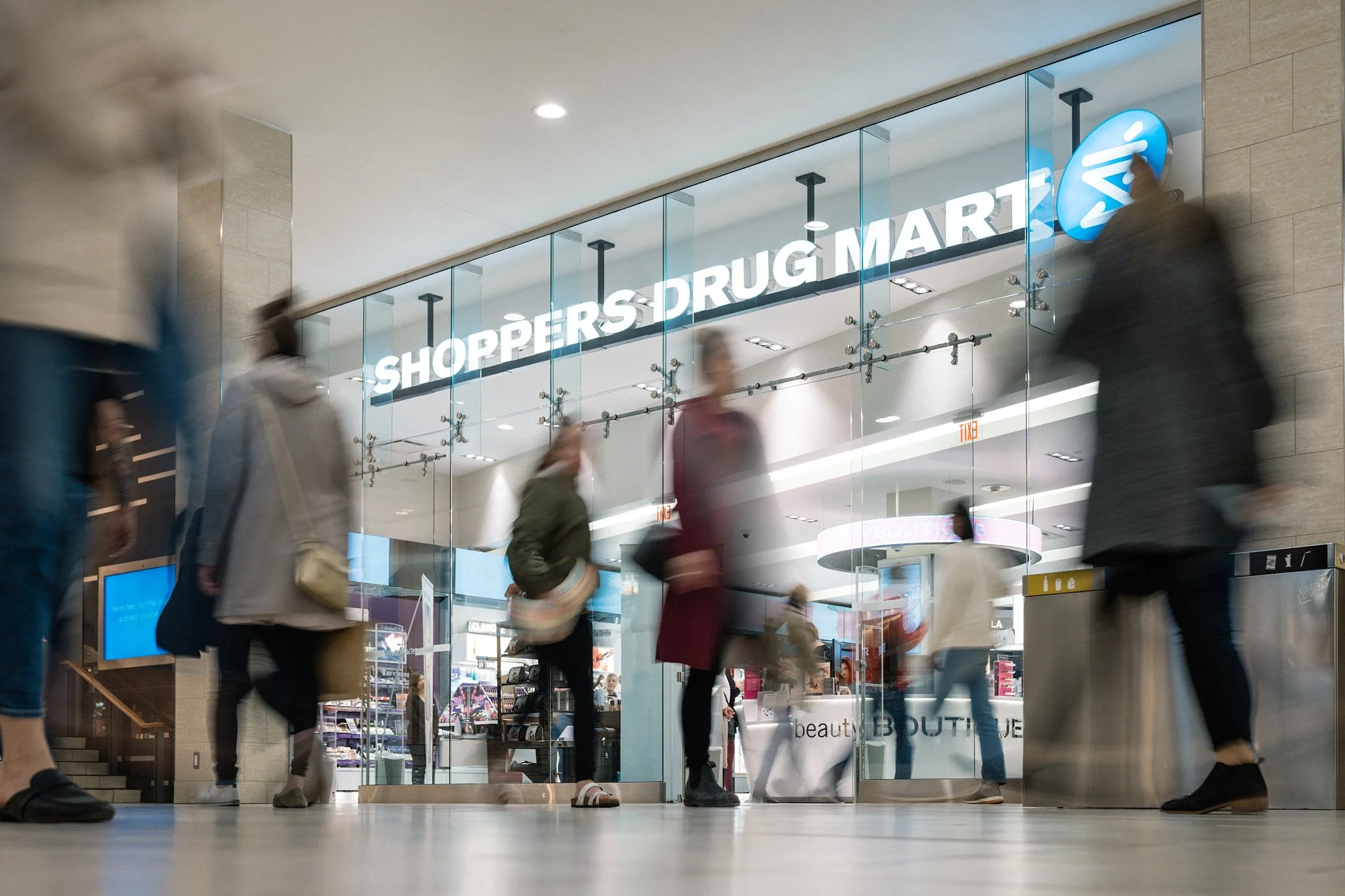 Shoppers Drug Mart Beauty Boutique storefront in Calgary's Chinook Mall – blurred shoppers and elegant glass displays creating a vibrant retail atmosphere. Professional event photography by Stance Creative.
