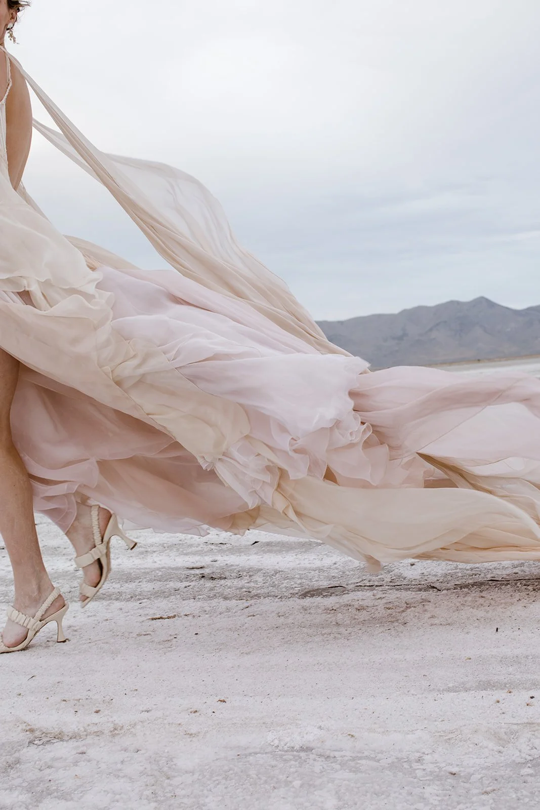Artistic blush bridal gown with pearl fringe and flowy silk chiffon panels