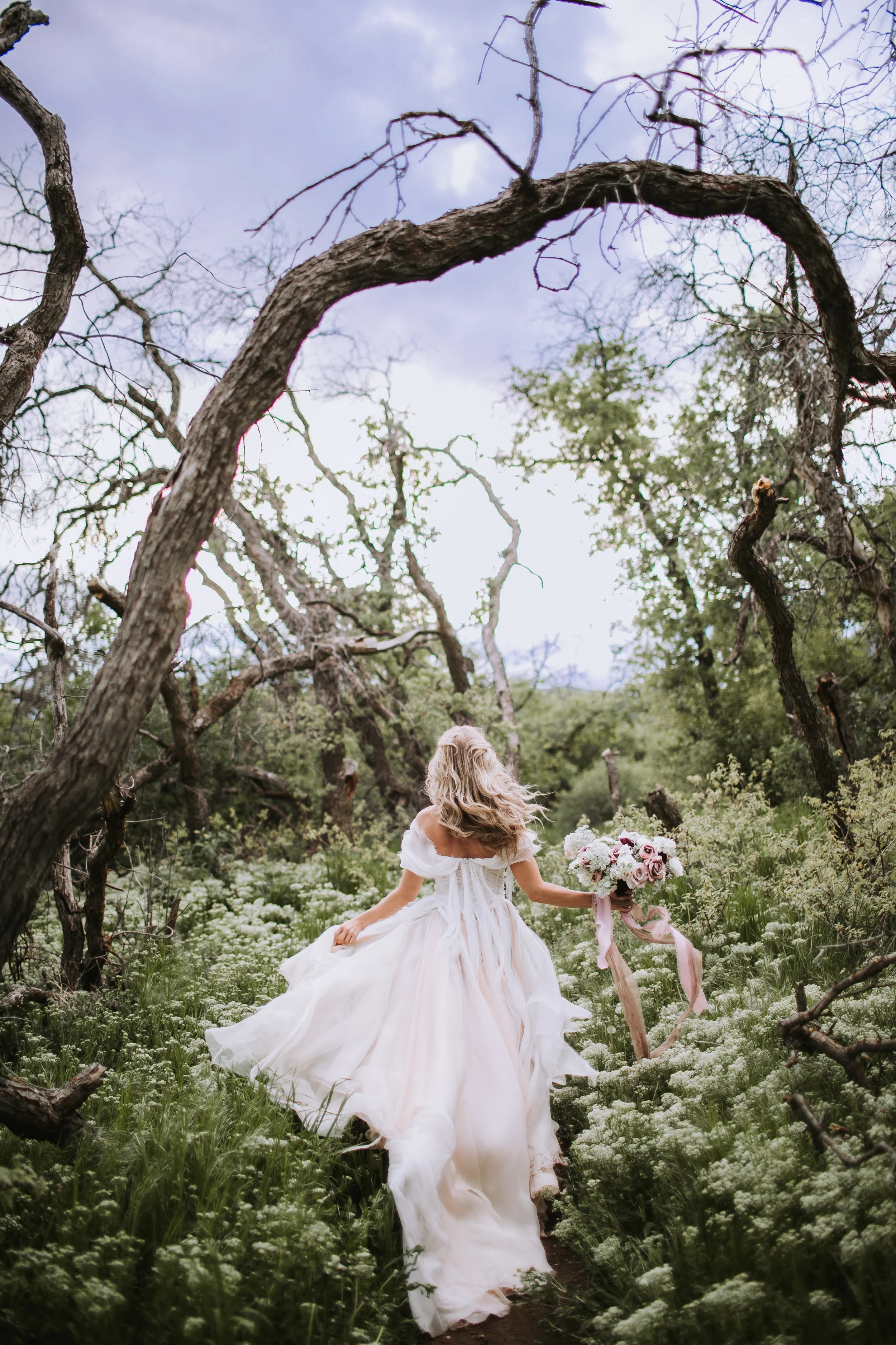 Fairytale whimsical wedding dress in mountain wildflower field 