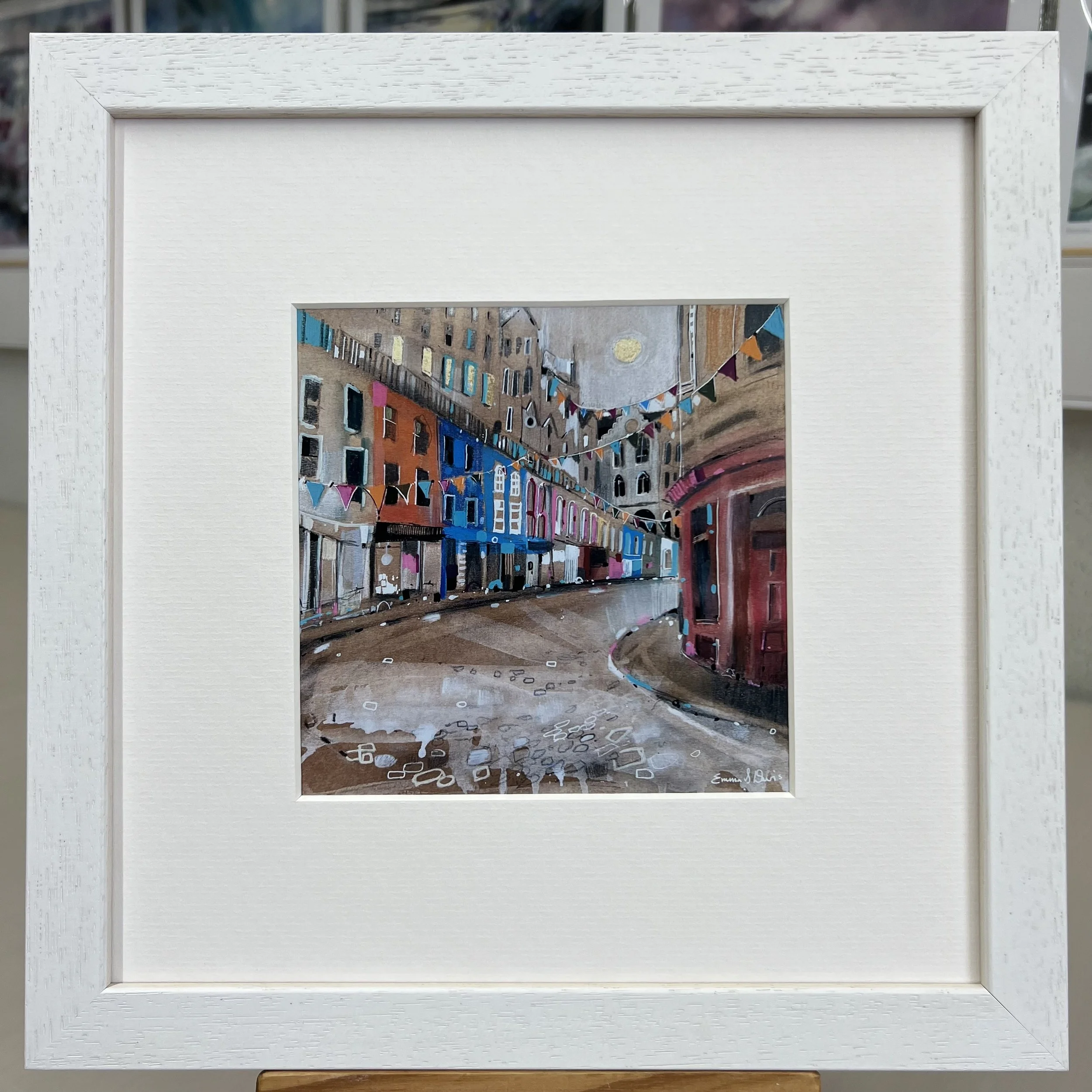 Bunting Victoria Street Edinburgh framed art card featuring colourful bunting and the famous curved street in Edinburgh, Scotland. Framed white single mount.