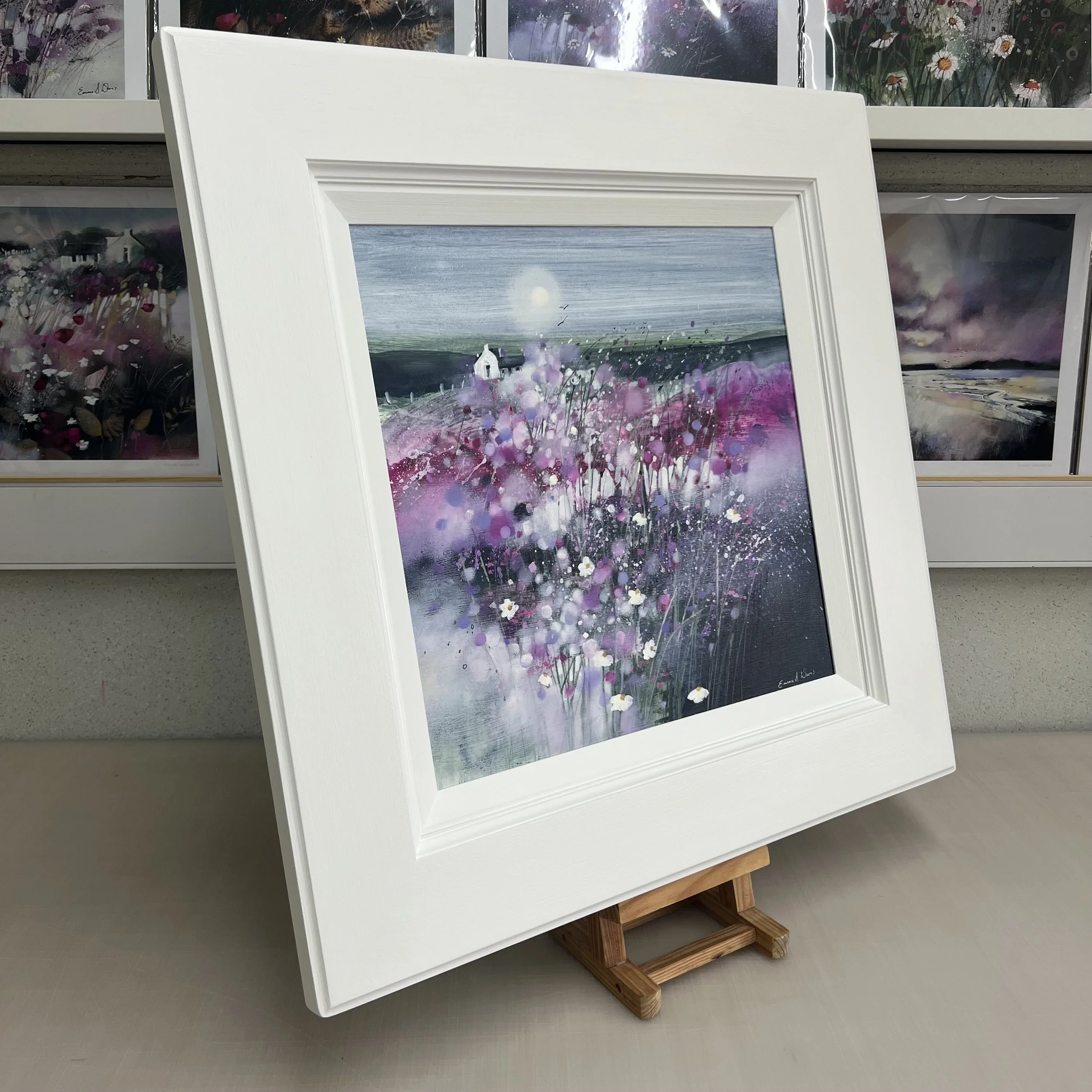 Dancing in the Moonlight by Emma S Davis – original Scottish landscape oil painting featuring a white cottage beneath a glowing moon surrounded by pink and purple wildflowers. Side view.