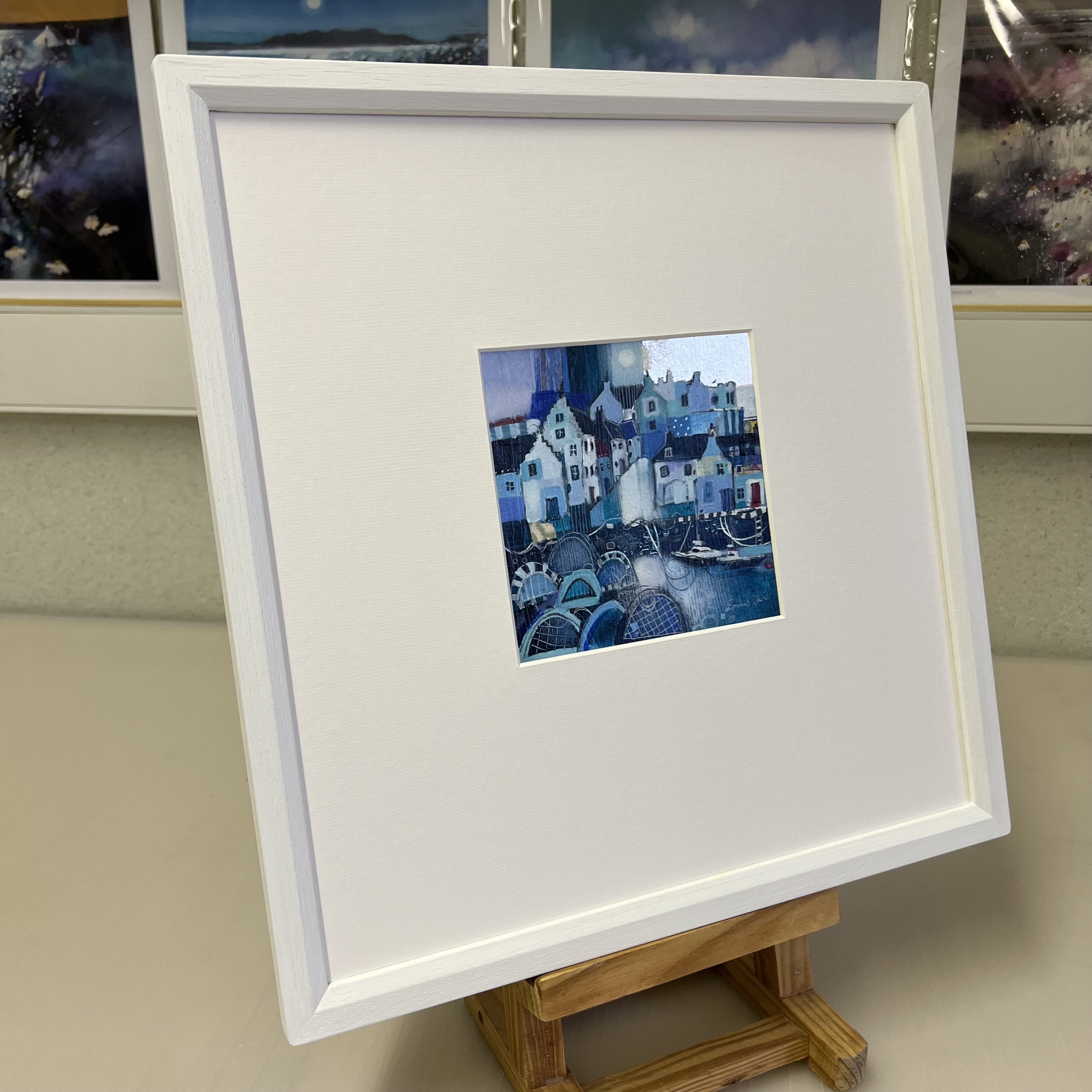 Side view of framed painting of East Neuk of Fife's traditional fishing village harbour of Crail caught in time by Emma S Davis Artist's 'Moonlight Shimmers, Crail' original painting.