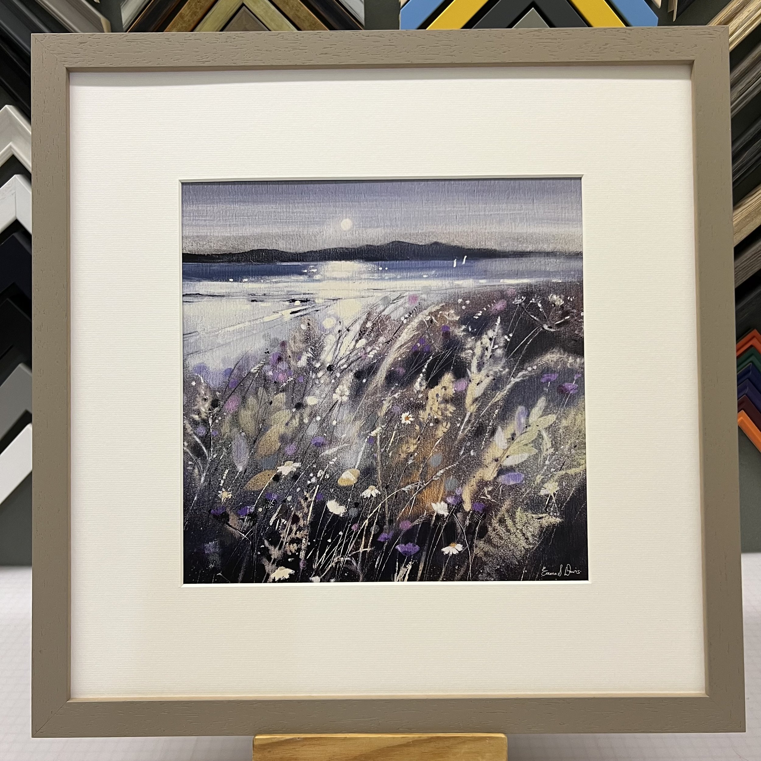 Summer Fields and Arran Open Edition Art Print by Emma S Davis. Presented in a light grey frame, showcasing Arran on the horizon and wildflowers dancing in the summer breeze.