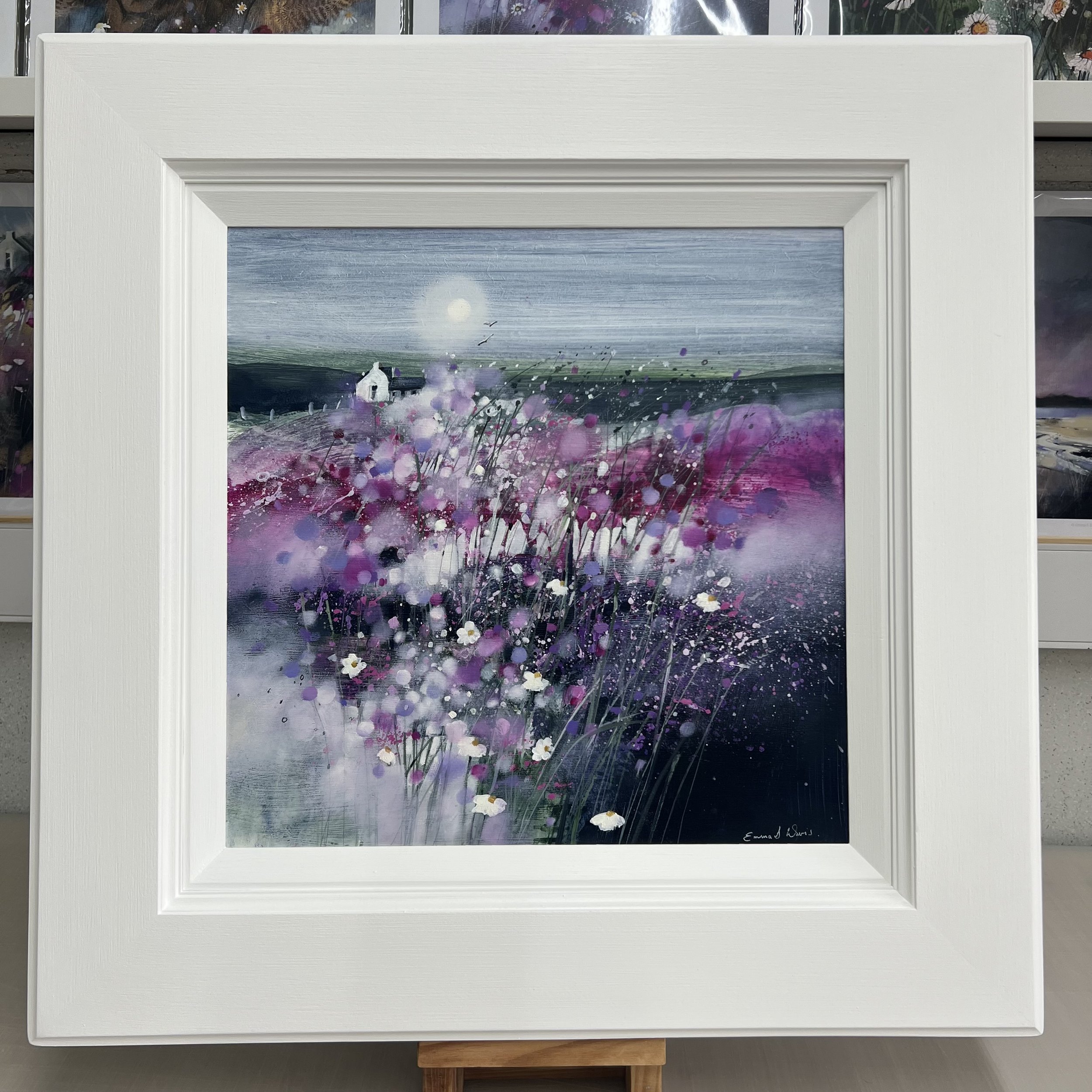 Dancing in the Moonlight by Emma S Davis – original Scottish landscape oil painting featuring a white cottage beneath a glowing moon surrounded by pink and purple wildflowers. Framed in white.