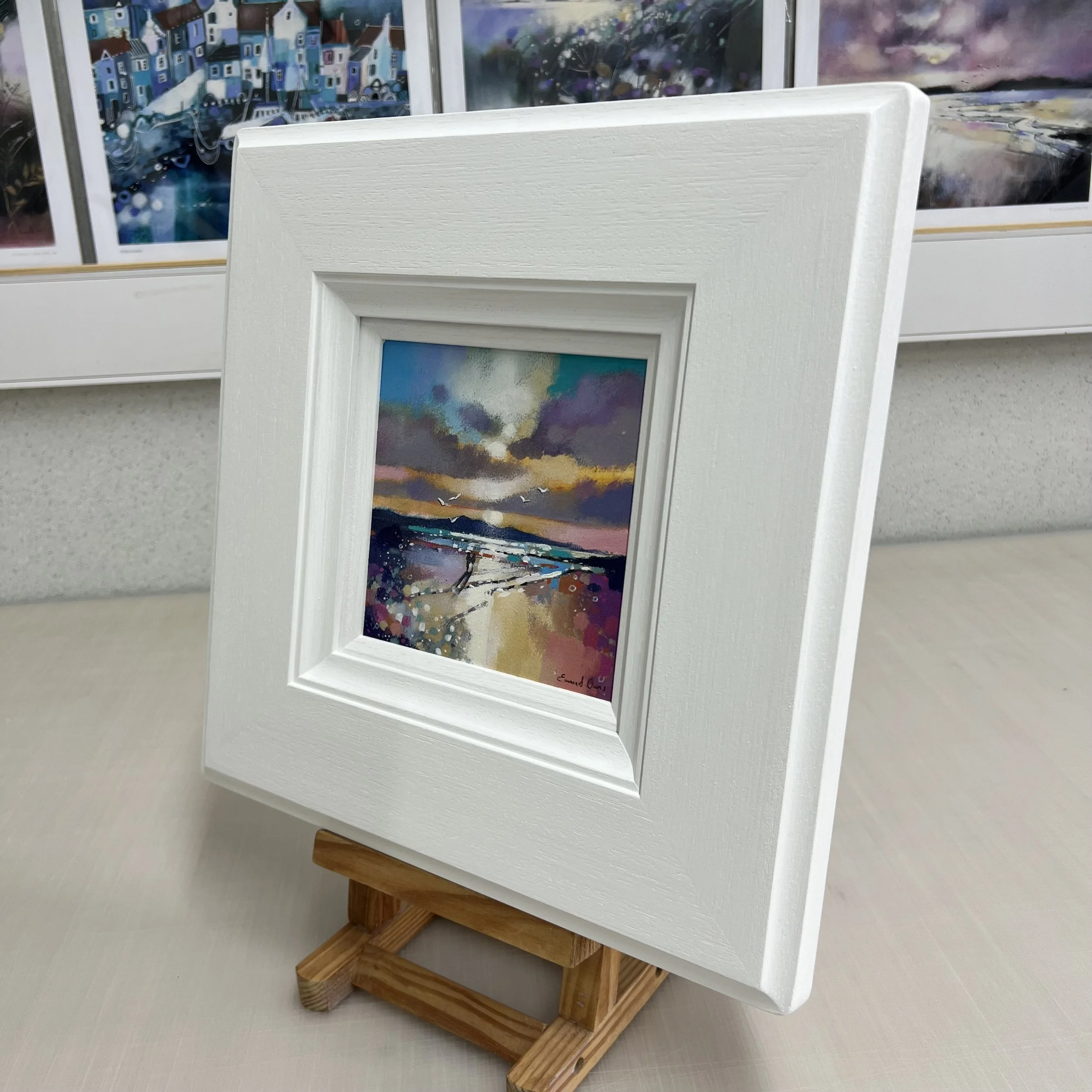 The Isle of Arran's silhouette frames couple walking along Seamill Beach in an original painting by Emma S Davis Artist. Side view.