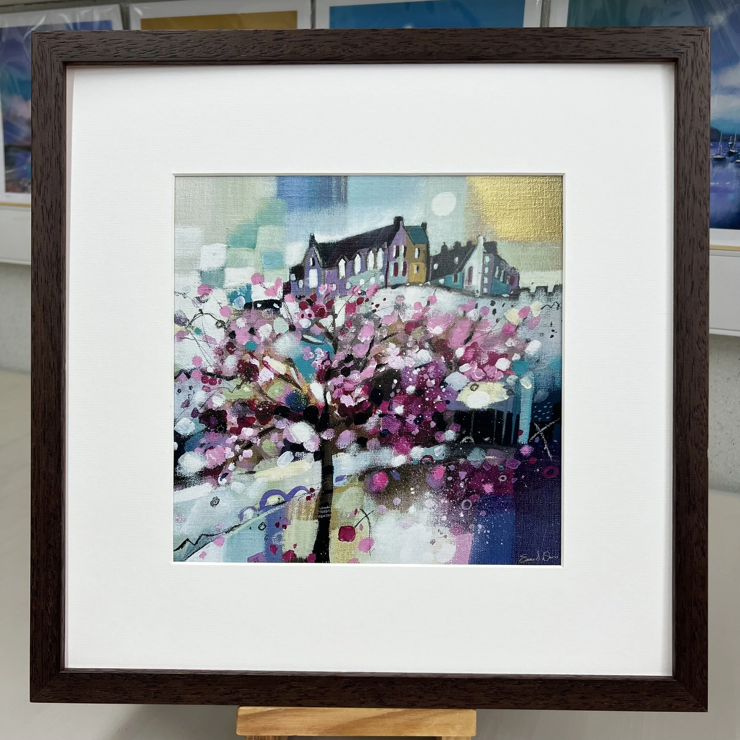 Blossom trees in Princes Street Gardens below Edinburgh Castle come to life in Emma S Davis Artist's open edition art print with brown frame.