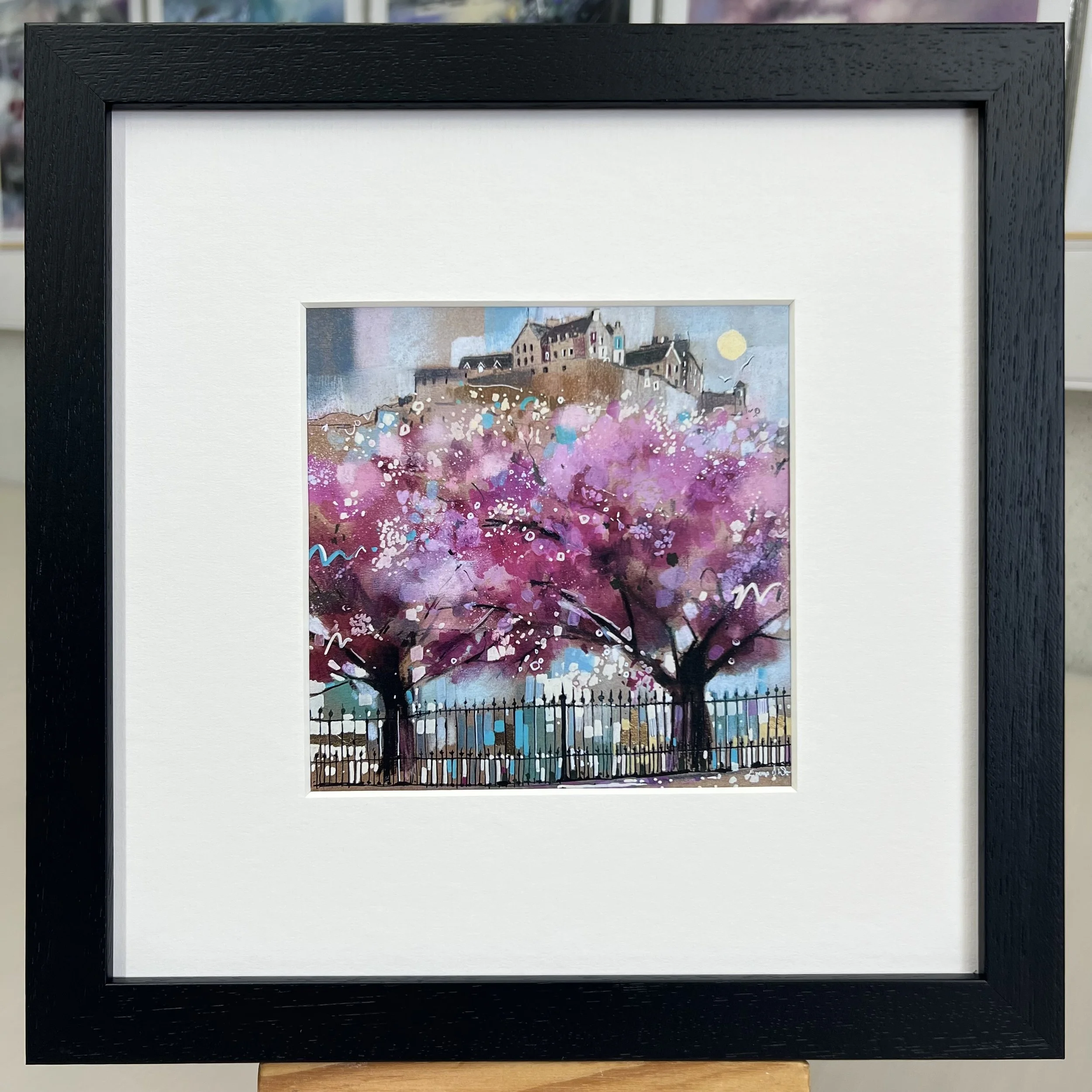 Edinburgh in Bloom framed art card featuring Edinburgh Castle above blossom trees in Princes Street Gardens, Scotland. Framed black single mount.