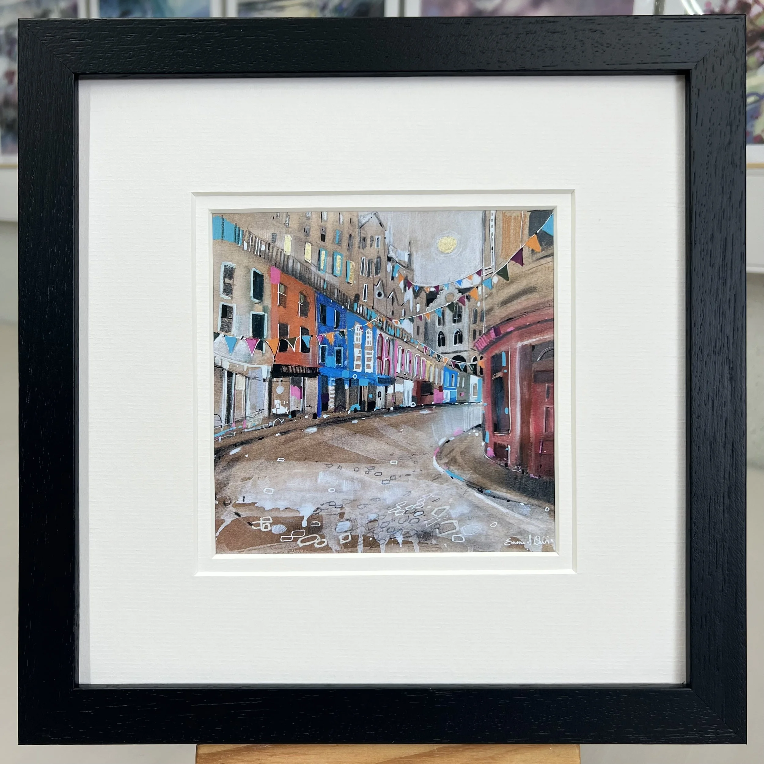 Bunting Victoria Street Edinburgh framed art card featuring colourful bunting and the famous curved street in Edinburgh, Scotland. Framed black double mount.