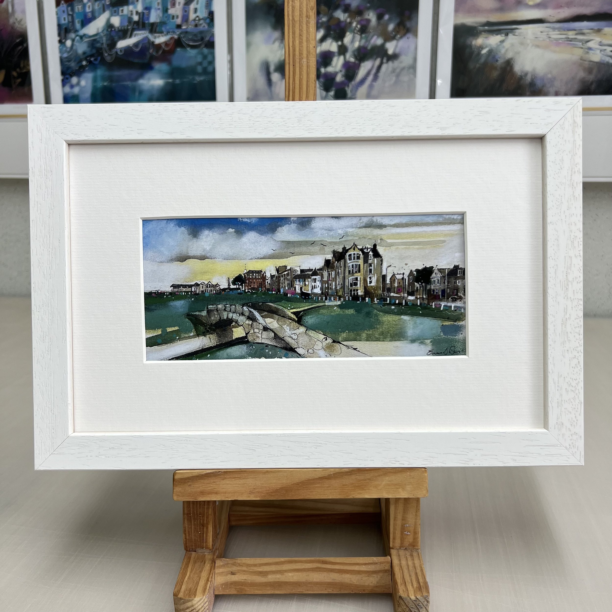 Framed Swilcan Bridge St Andrews artwork showing Old Course 18th green and clubhouse. White frame.