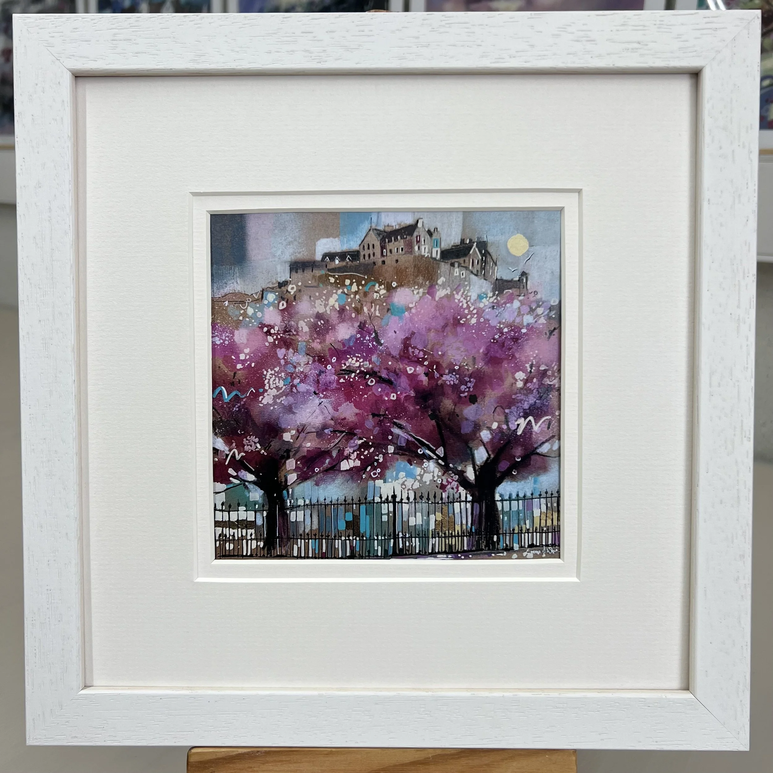 Edinburgh in Bloom framed art card featuring Edinburgh Castle above blossom trees in Princes Street Gardens, Scotland. Framed white double mount.