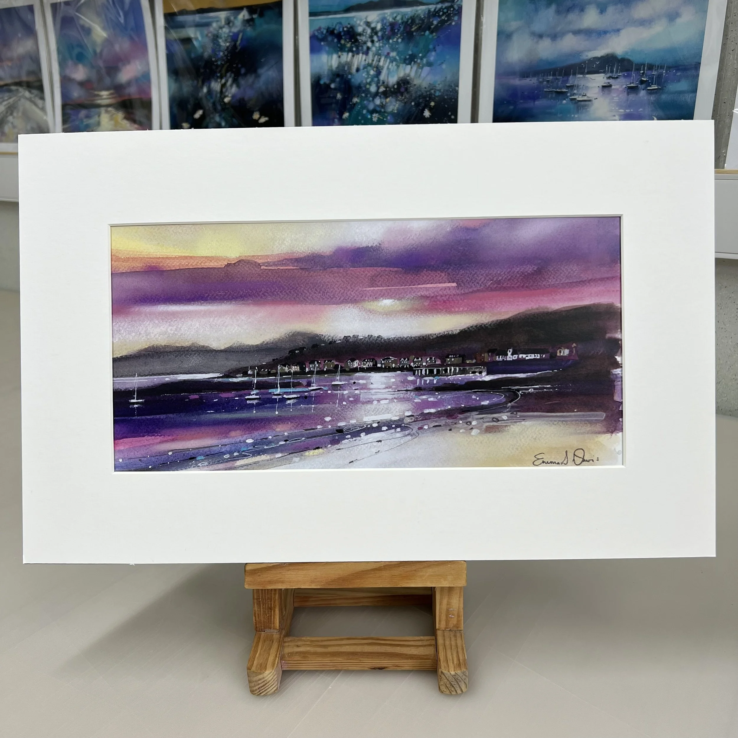 The view from Millport beach looking towards West Bay and Arran beyond on the Isle of Cumbrae, Scotland depicted beautifully in Emma S Davis Artist's open edition mounted art print.