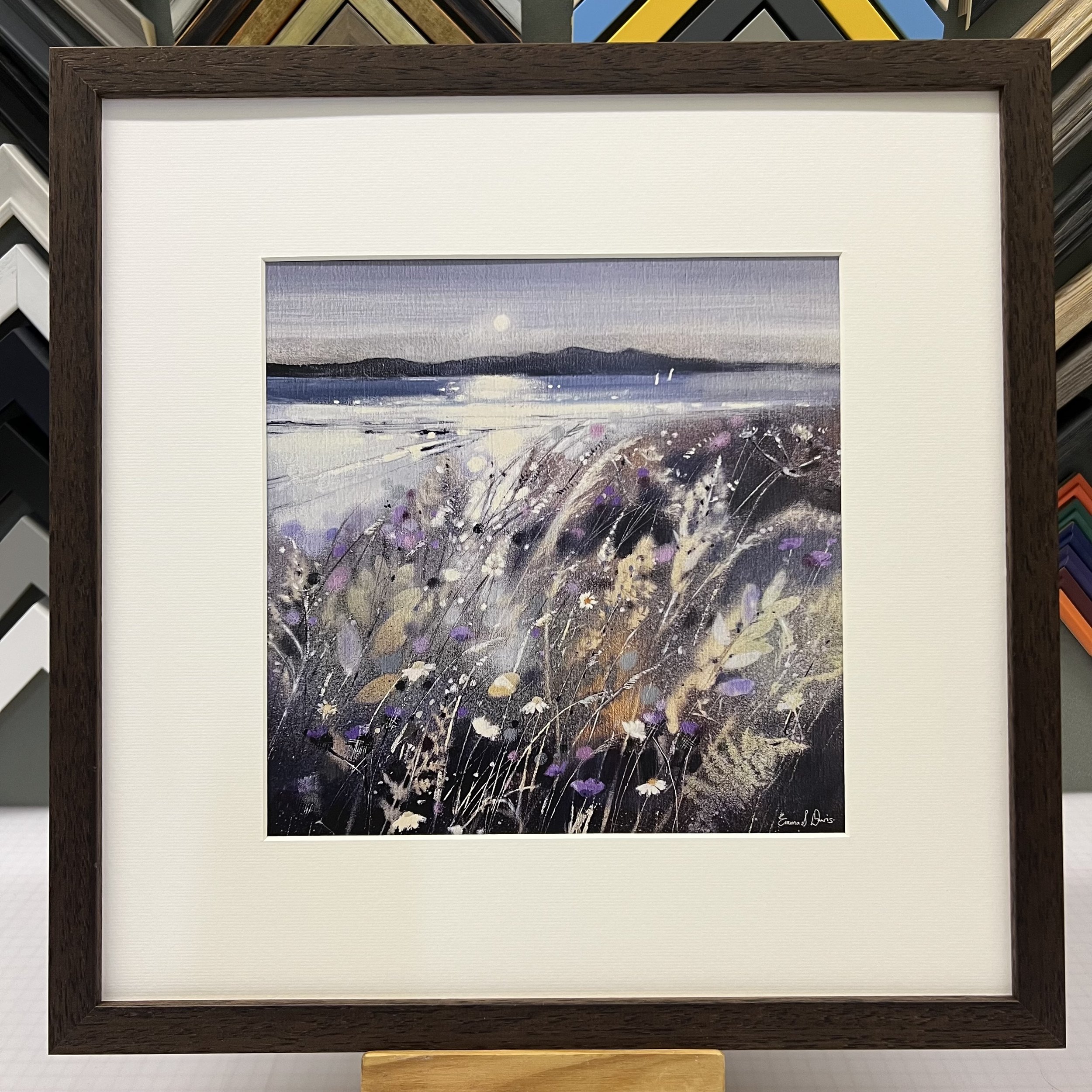 Summer Fields and Arran Open Edition Art Print by Emma S Davis. Presented in a brown frame, showcasing Arran on the horizon and wildflowers dancing in the summer breeze.