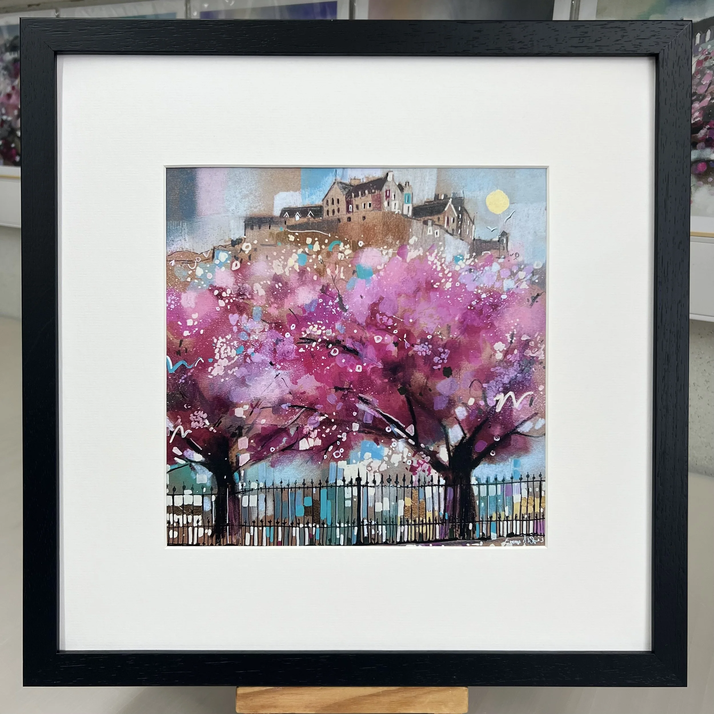Edinburgh in Bloom artwork featuring Edinburgh Castle above blossom trees in Princes Street Gardens, Scotland. Framed in black option.
