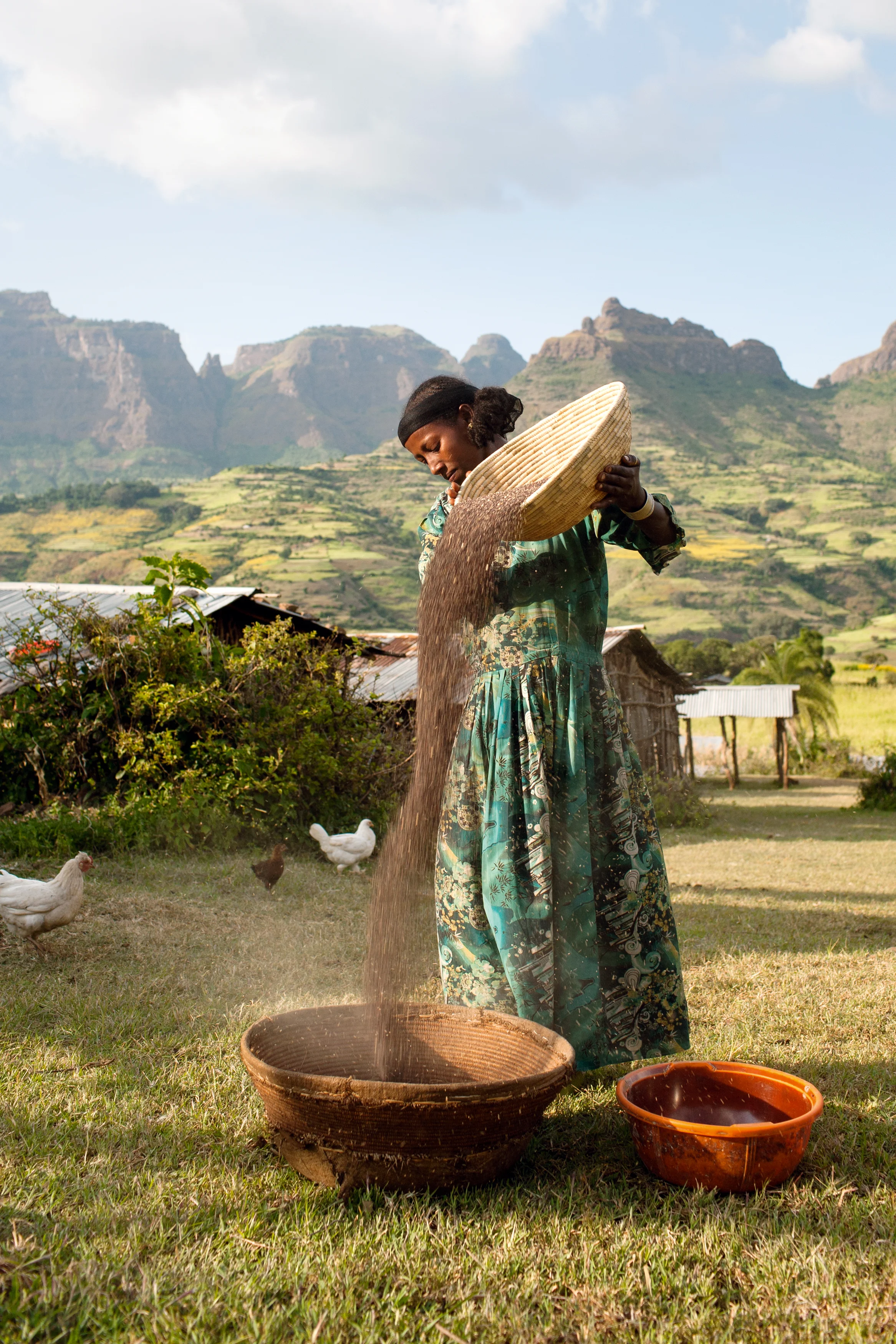 Azanu is winnowing millet outside her house in Lamu, a village in the lowlands of the stunning Simien Mountains in northern Ethiopia.