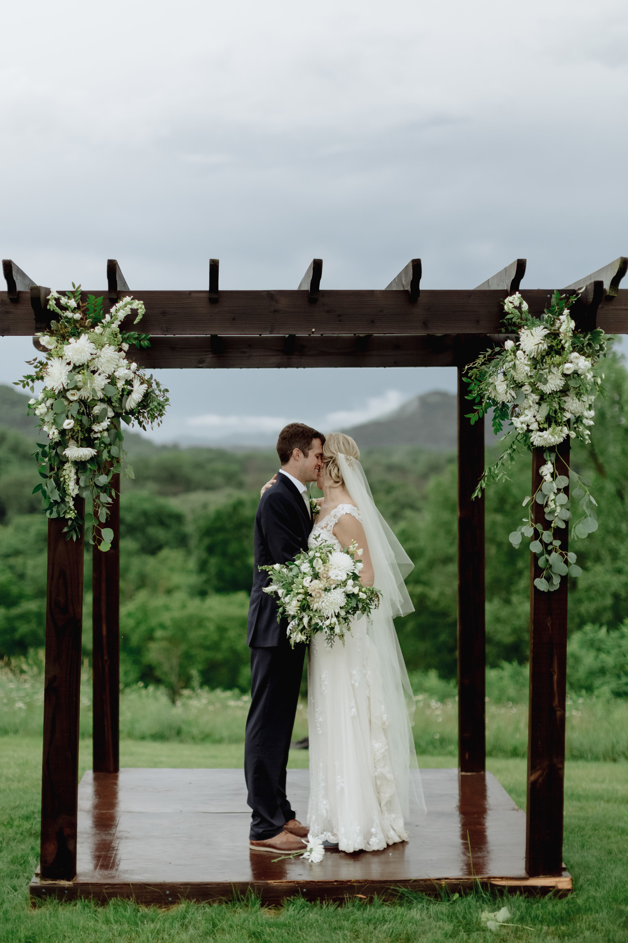Thankfully the storms subsided post-ceremony long enough for them to get some beautiful hilltop photos (those poor arch flowers took a beating in the rain!).